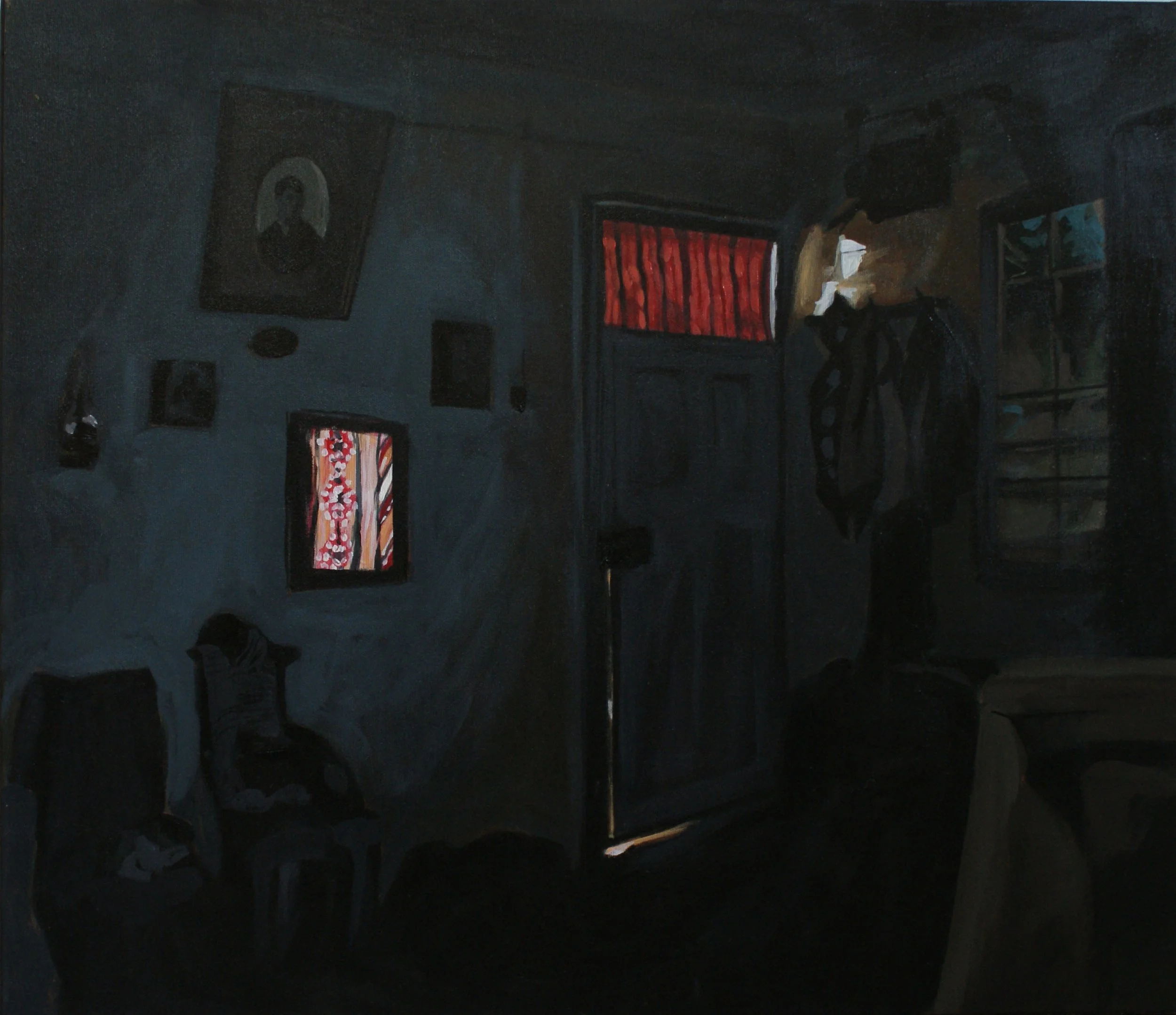 Dark interior of a room with a slightly ajar door letting in light, patterned curtains, and framed pictures on the wall.