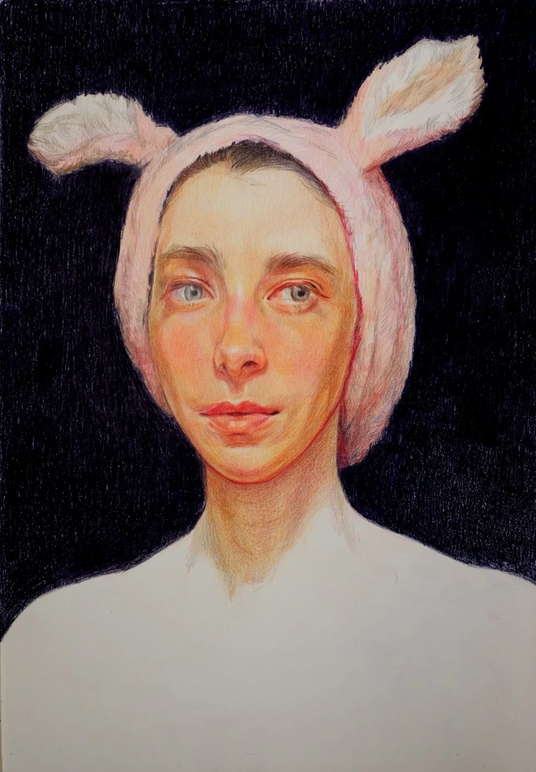 A portrait of a young woman with light skin and blue eyes, wearing a pink headband with bunny ears, against a black background.