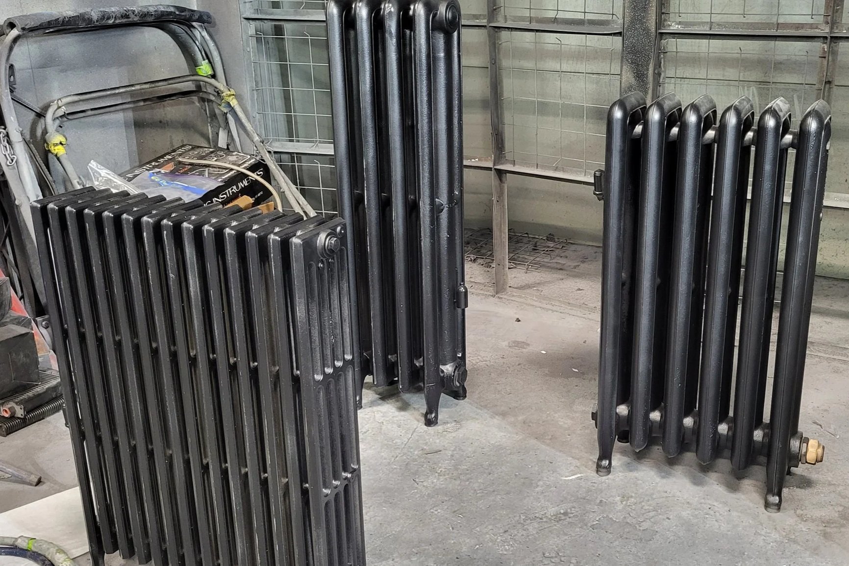 Black cast-iron radiators standing in a workshop