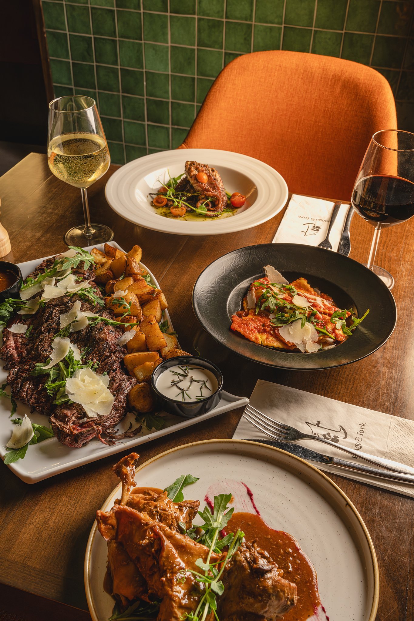 Restaurant table spread with salads, mains and wine, food photography Malta