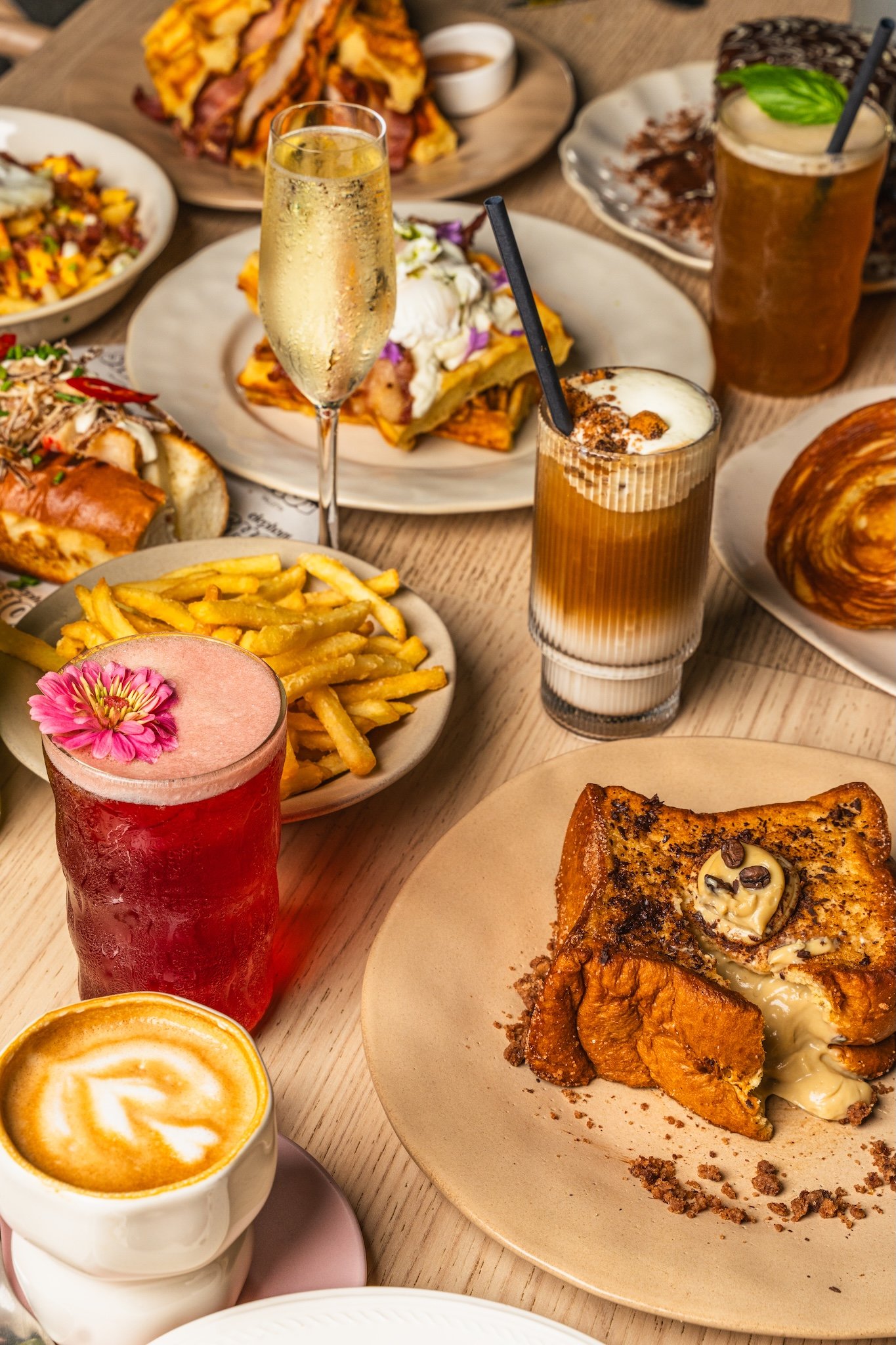 Overhead brunch table with pastries, fries and iced drinks, food photography Malta