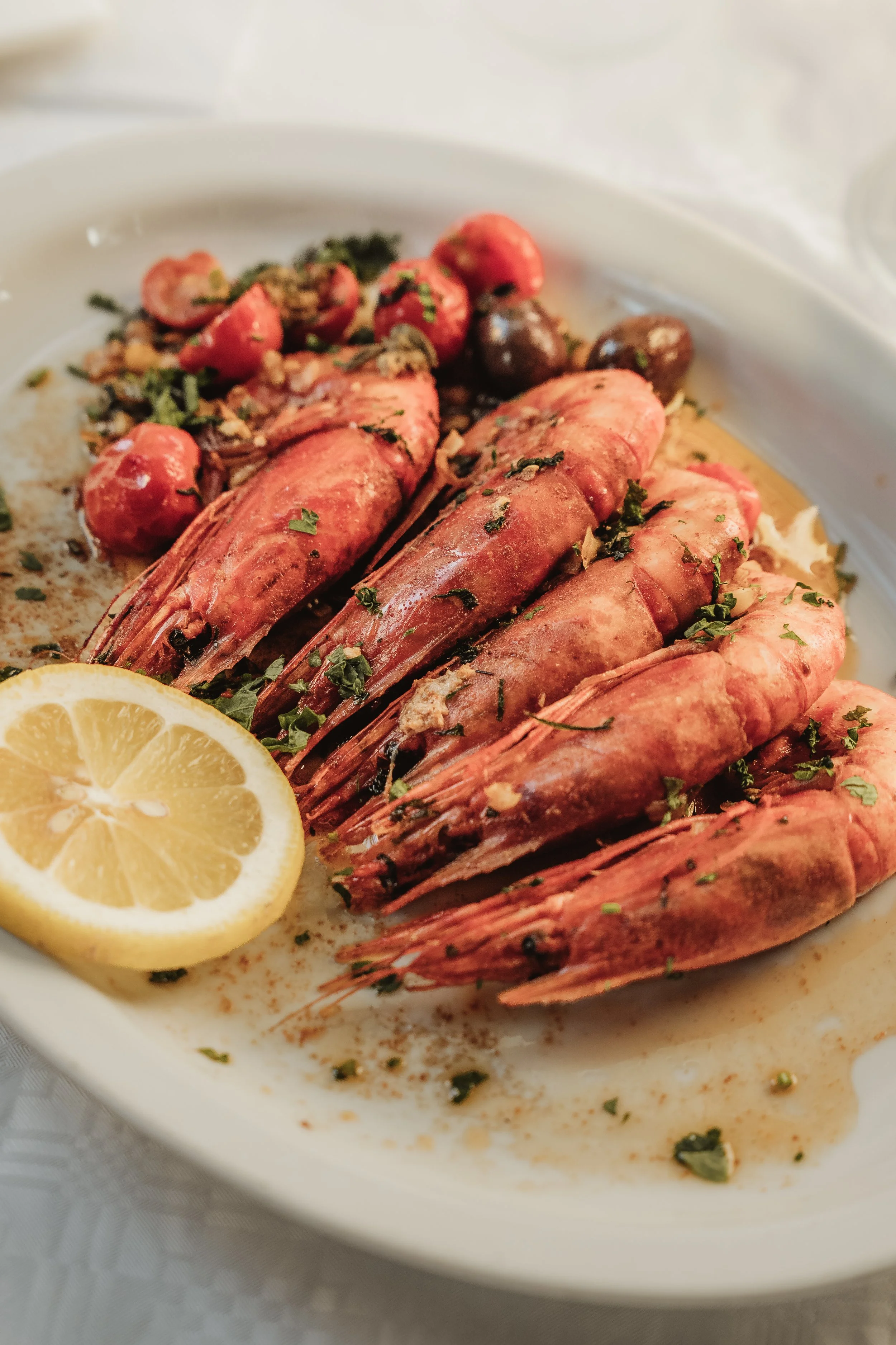 Red prawns with lemon on a white plate, seafood photography for a Malta restaurant