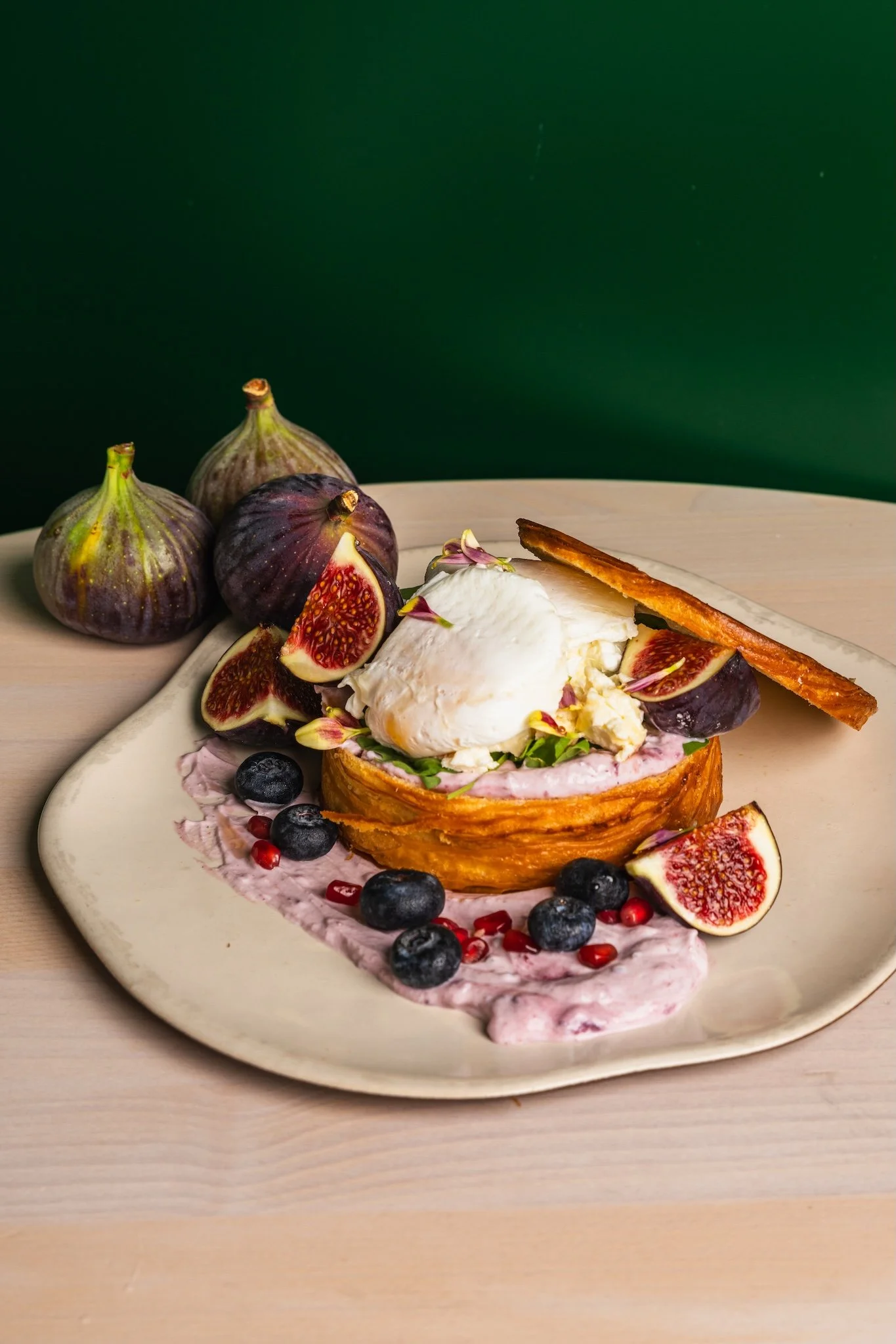 French toast with figs, berries and cream on a green table, food photography Malta