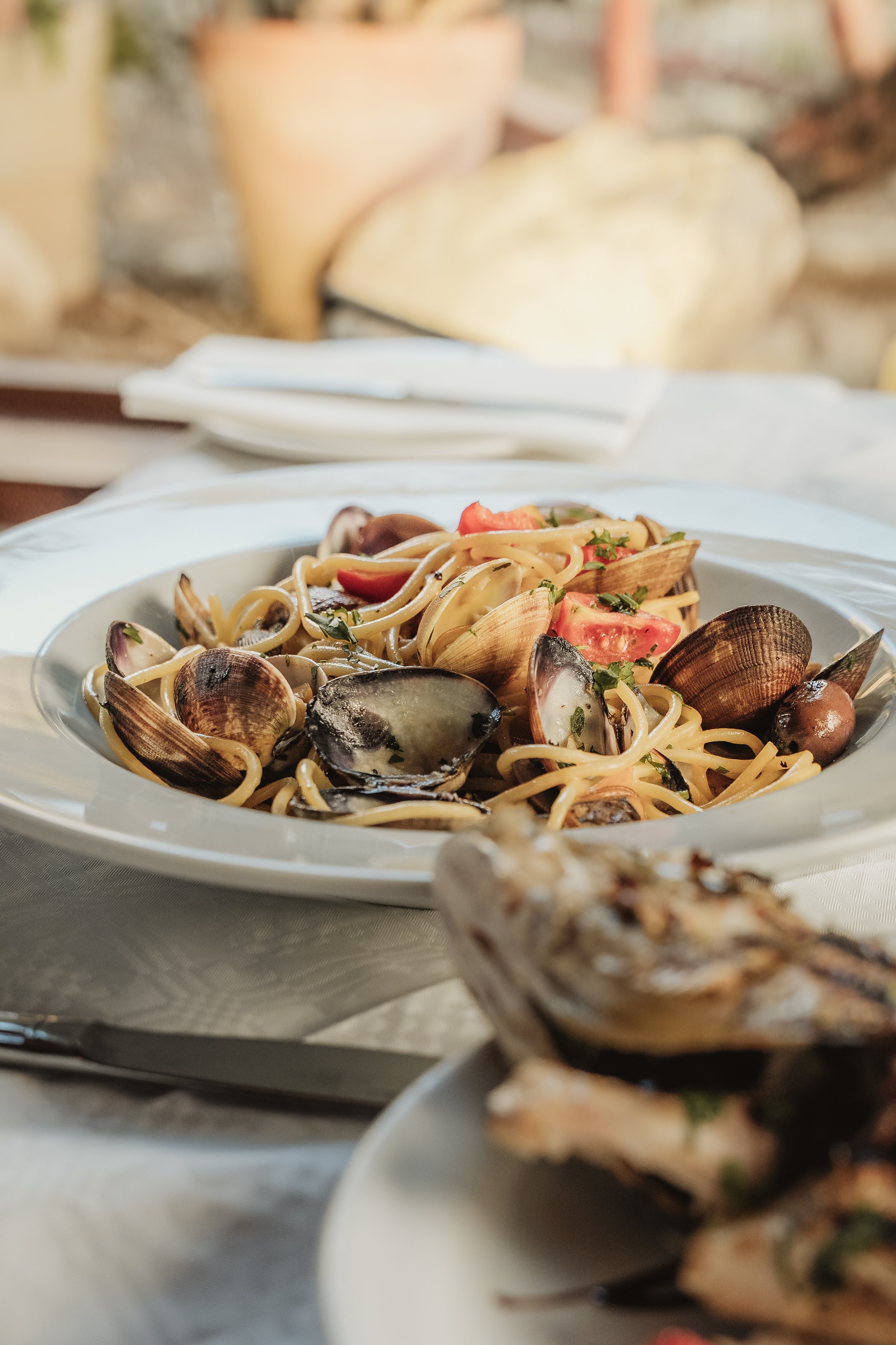 Spaghetti with clams and mussels on a white tablecloth, restaurant food photography Malta