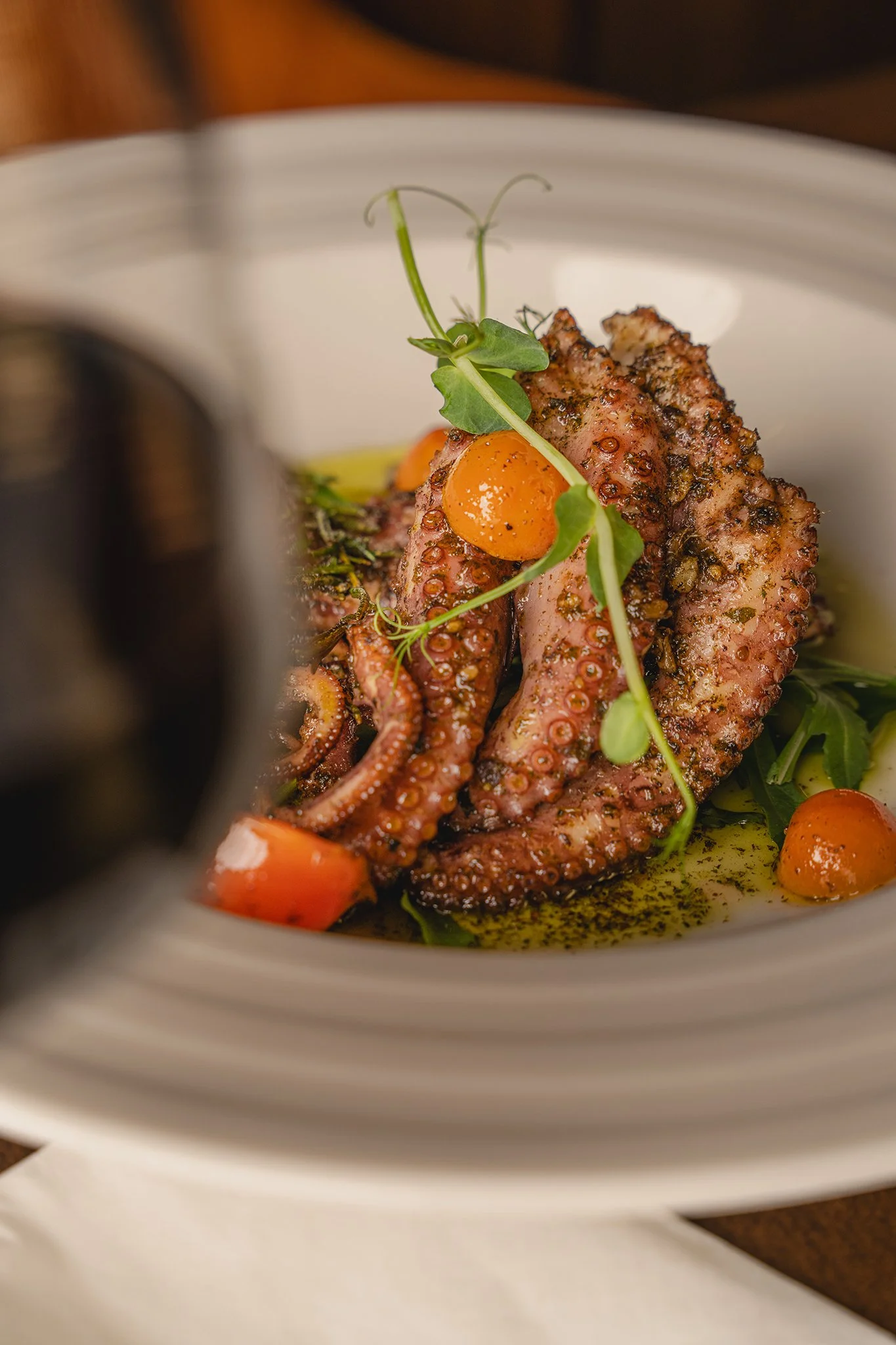 Grilled octopus with tomatoes and microgreens, food photography for a restaurant in Malta