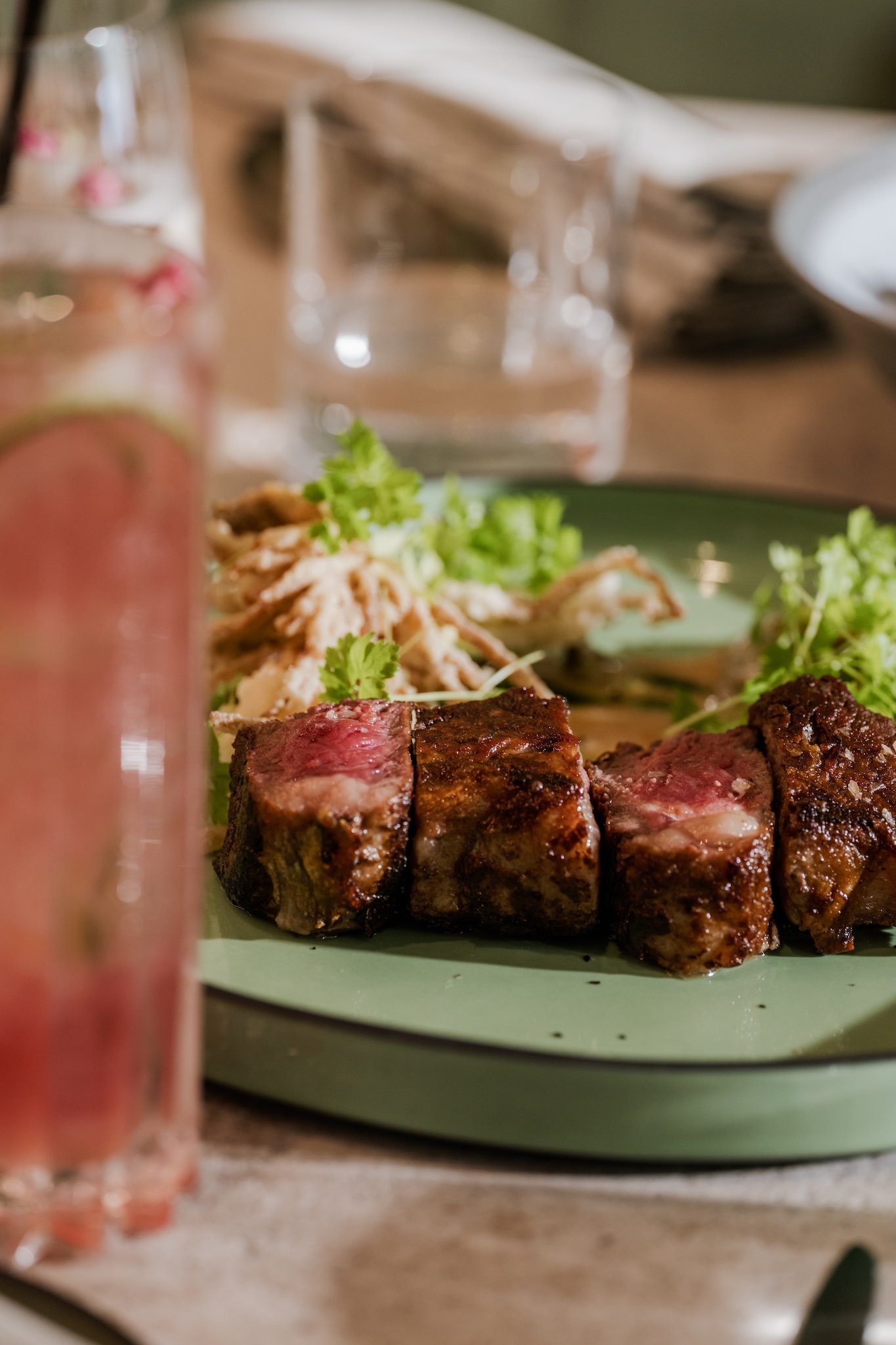 Sliced steak with salad and a pink drink, restaurant food photography Malta