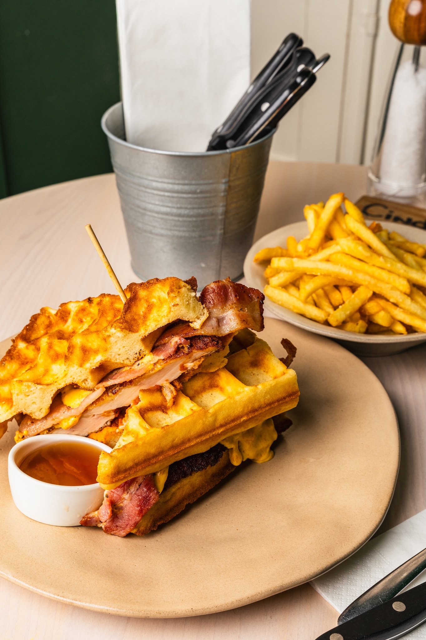 Chicken and waffles with fries on a café table, brunch food photography Malta