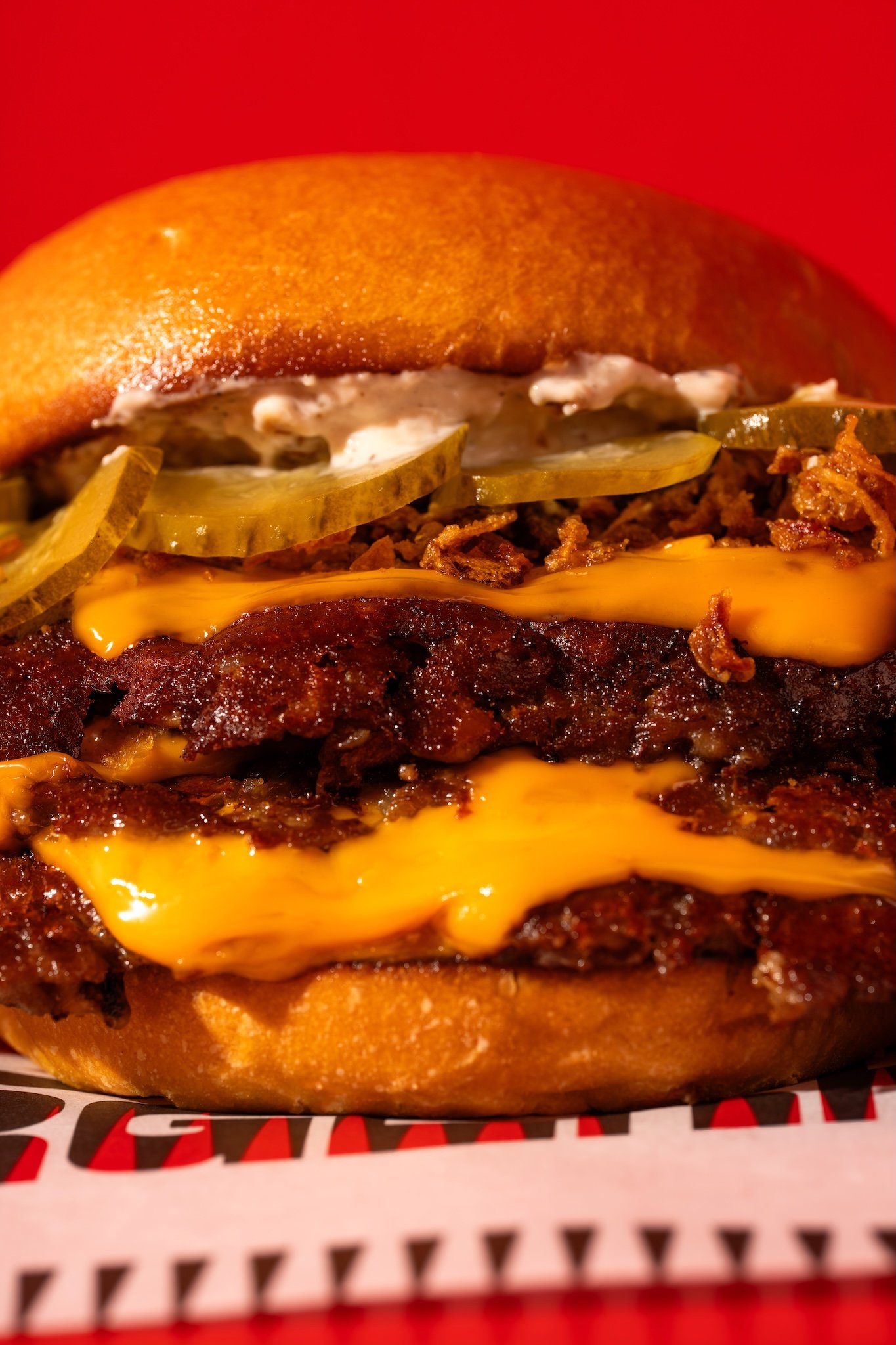 Double cheeseburger close-up on a red background, food photography for a burger restaurant