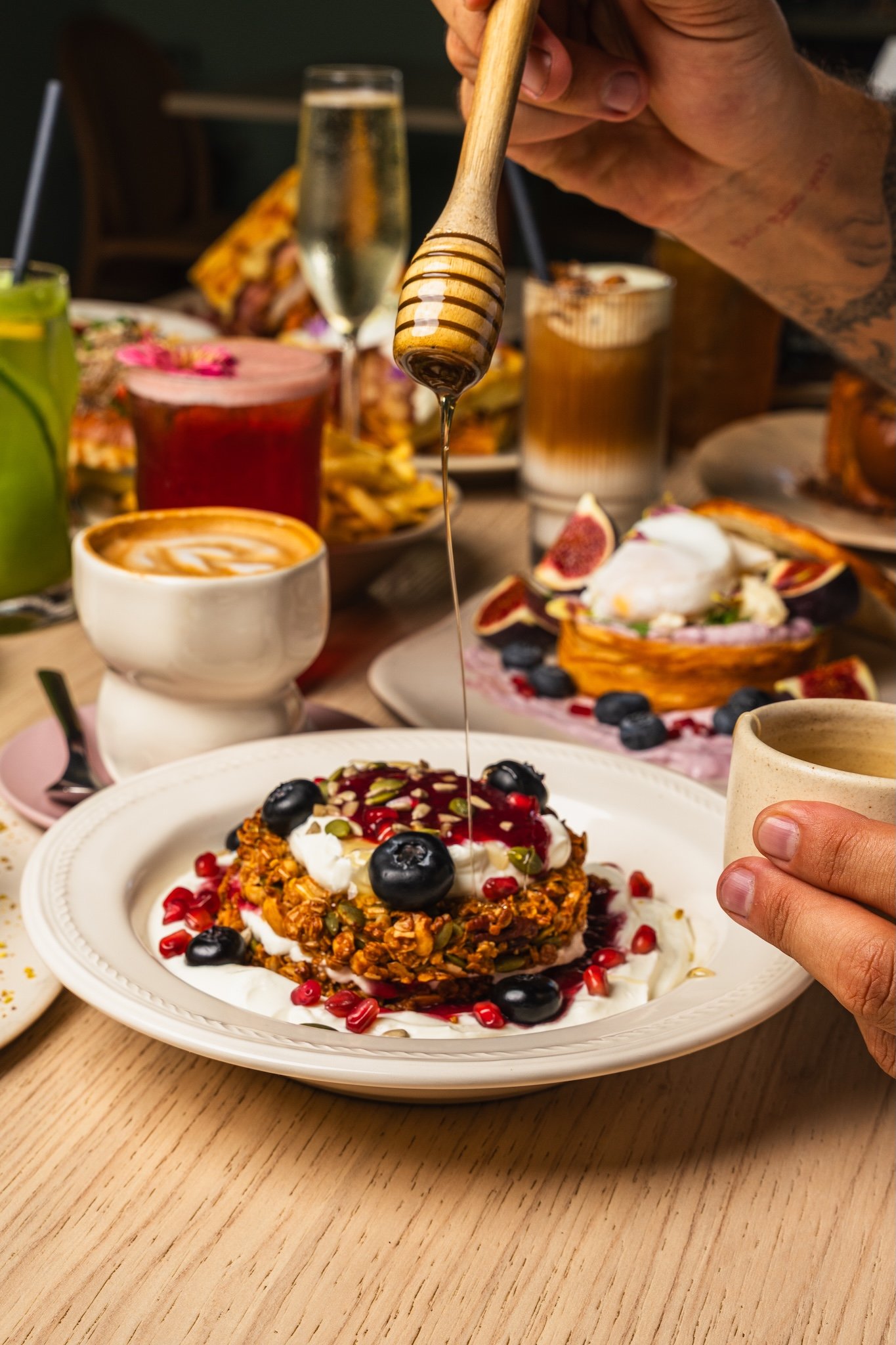 Honey being drizzled over pancakes on a brunch table, food photography Malta