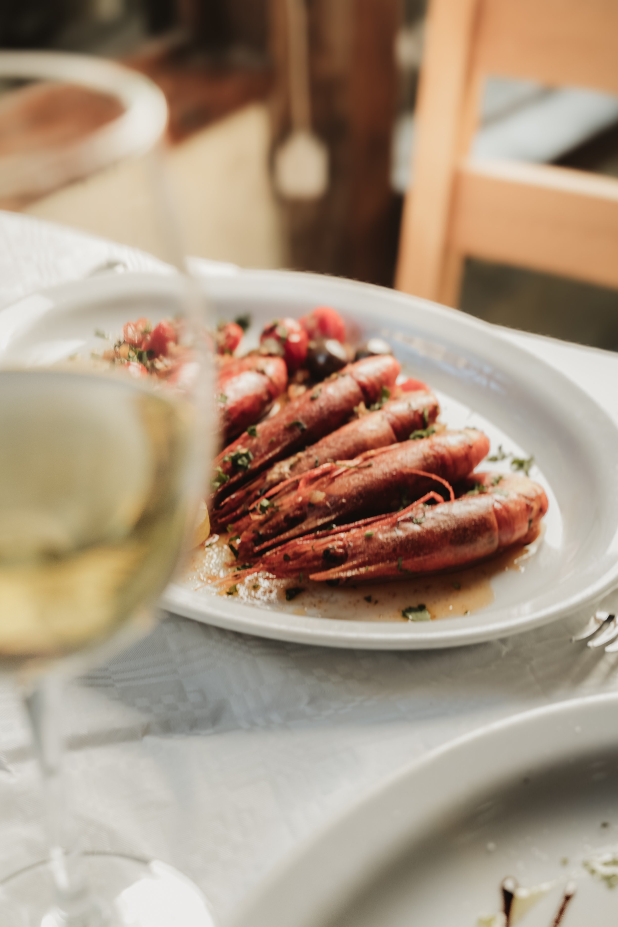 Grilled prawns with a glass of white wine, seafood restaurant photography Malta
