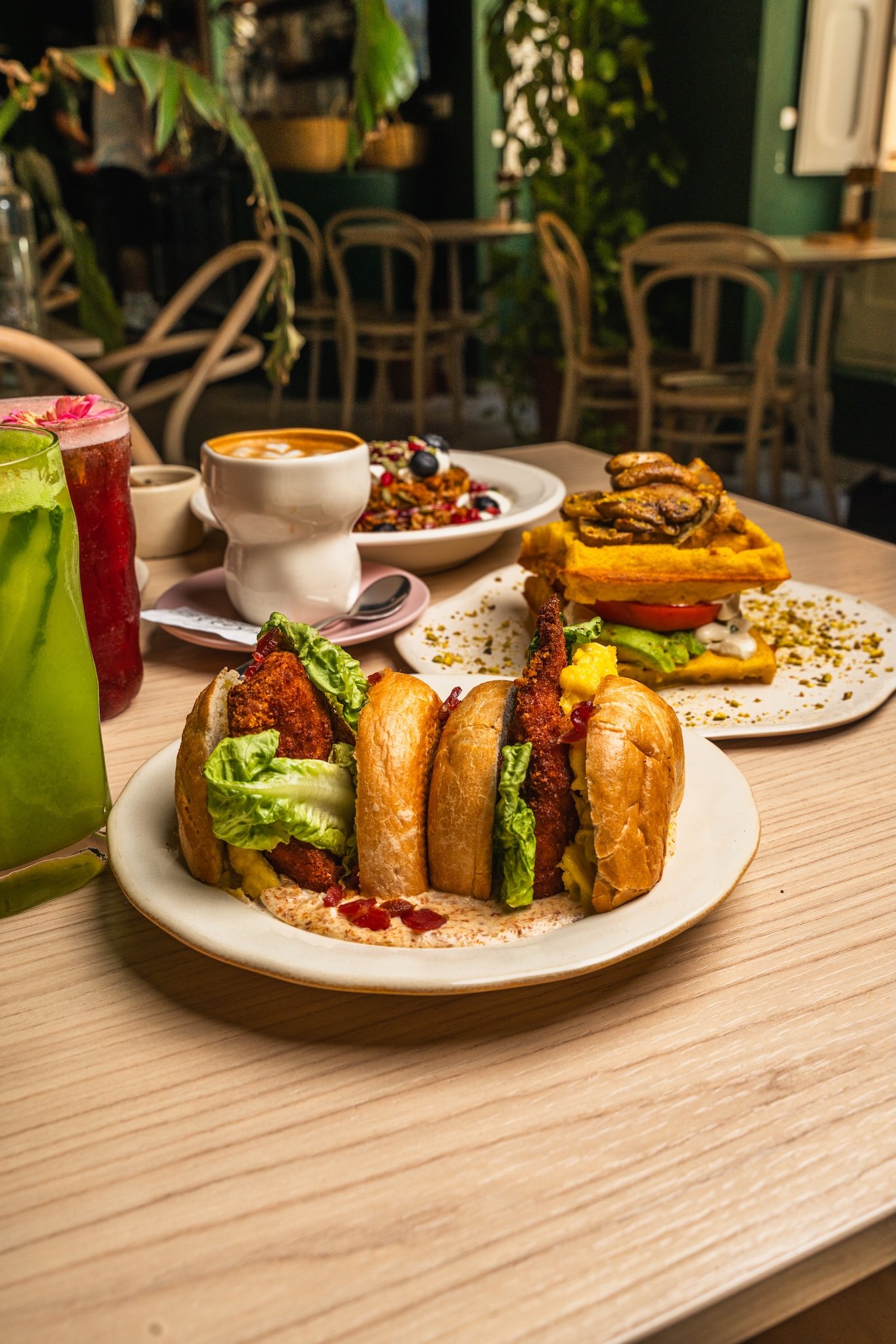 Burger with fresh greens on a café table surrounded by plants, restaurant photography Malta