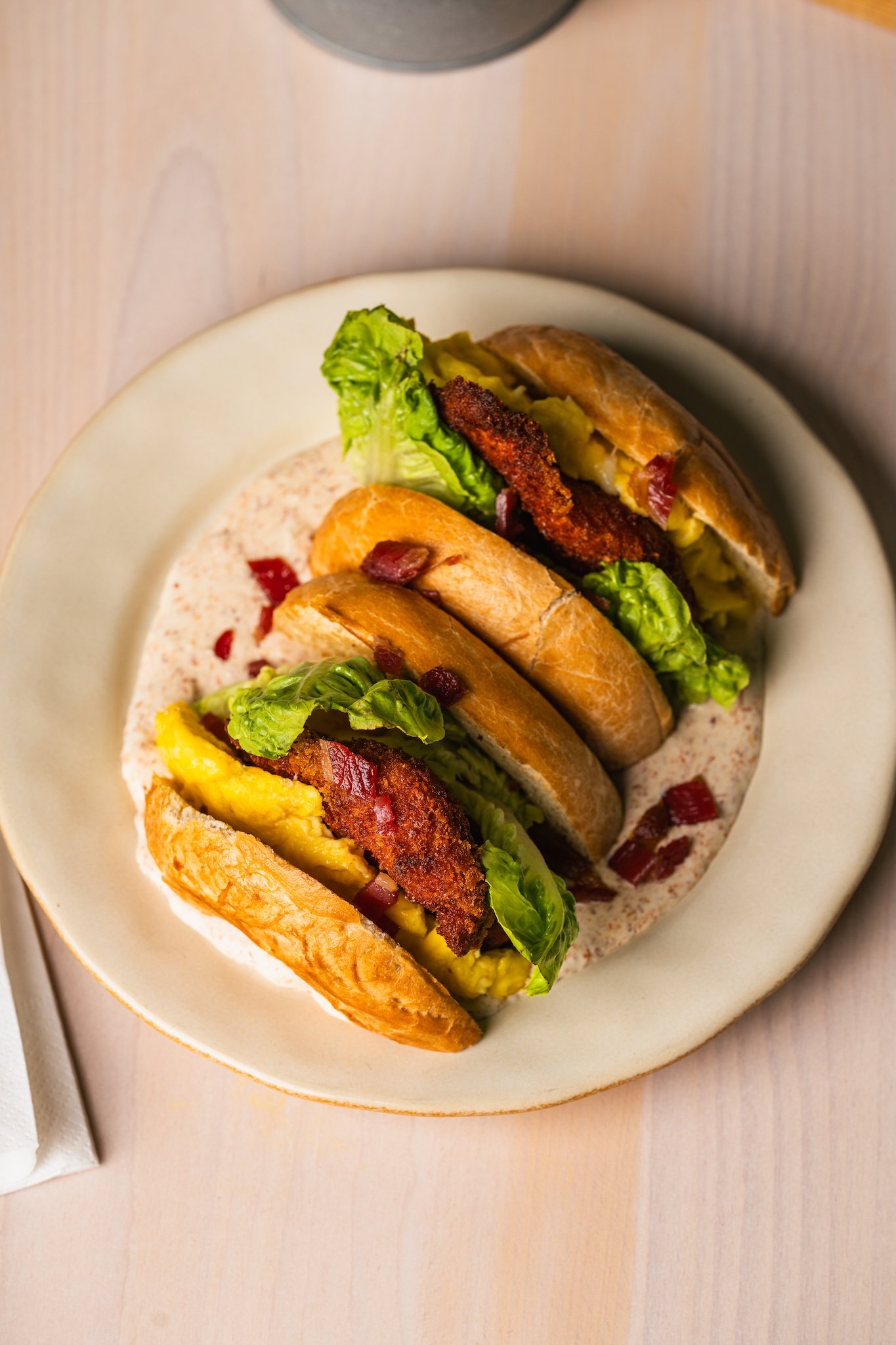 Stacked fried chicken sandwich with lettuce on a plate, café food photography Malta