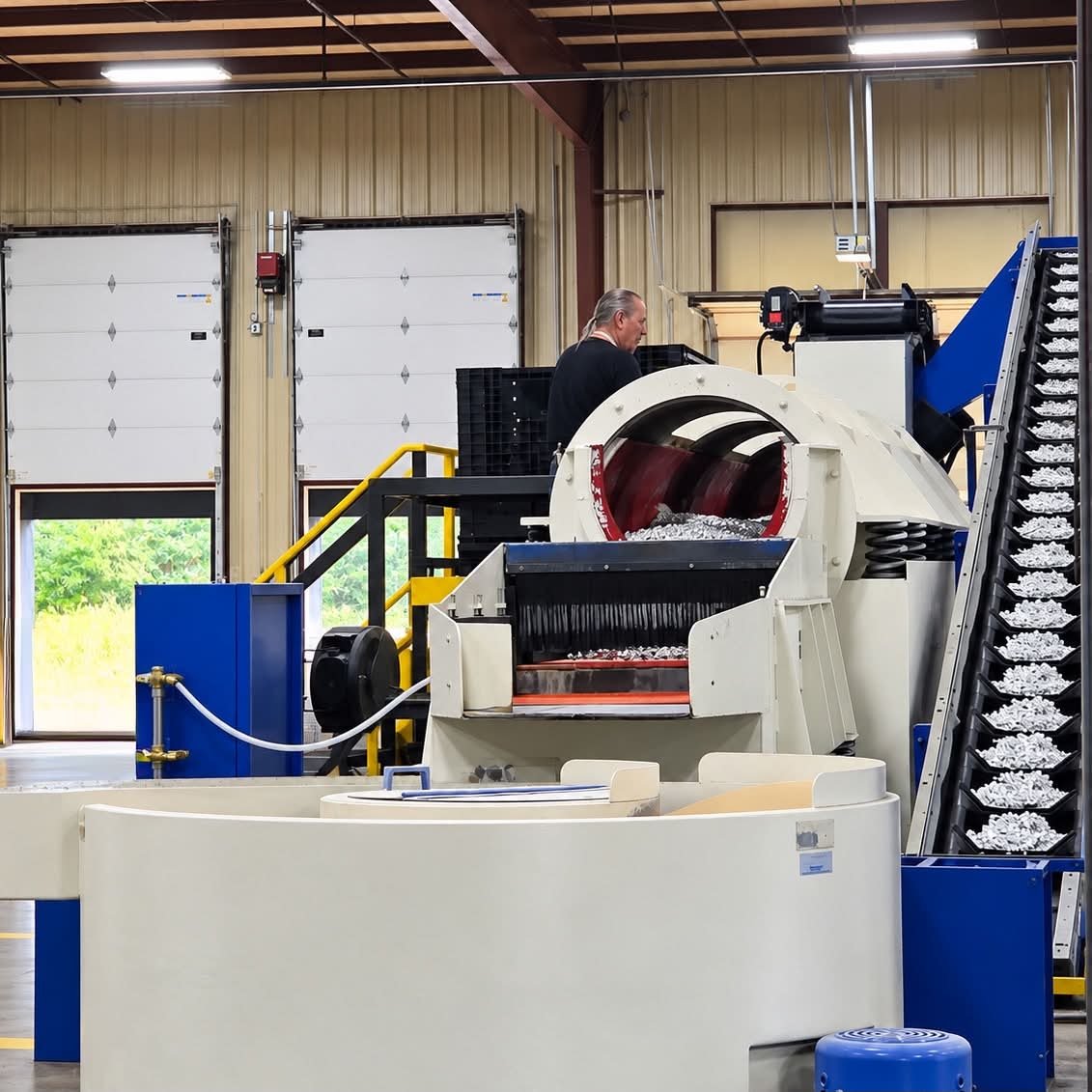 Industrial recycling machine processing crushed aluminum cans in a manufacturing facility