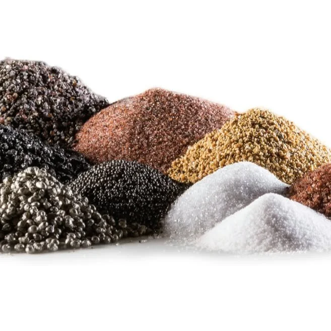 Close-up of assorted colorful granular abrasive materials in black, brown, gold, silver, and white piles