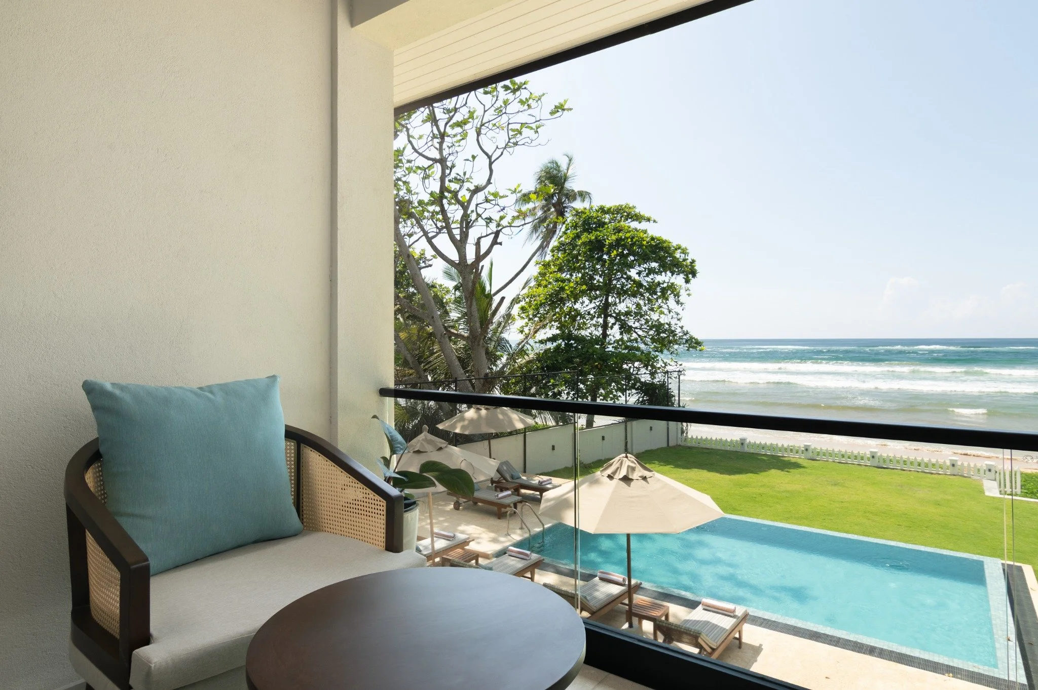 Balcony seating at SAYU overlooking the private pool, lawn and Indian Ocean.