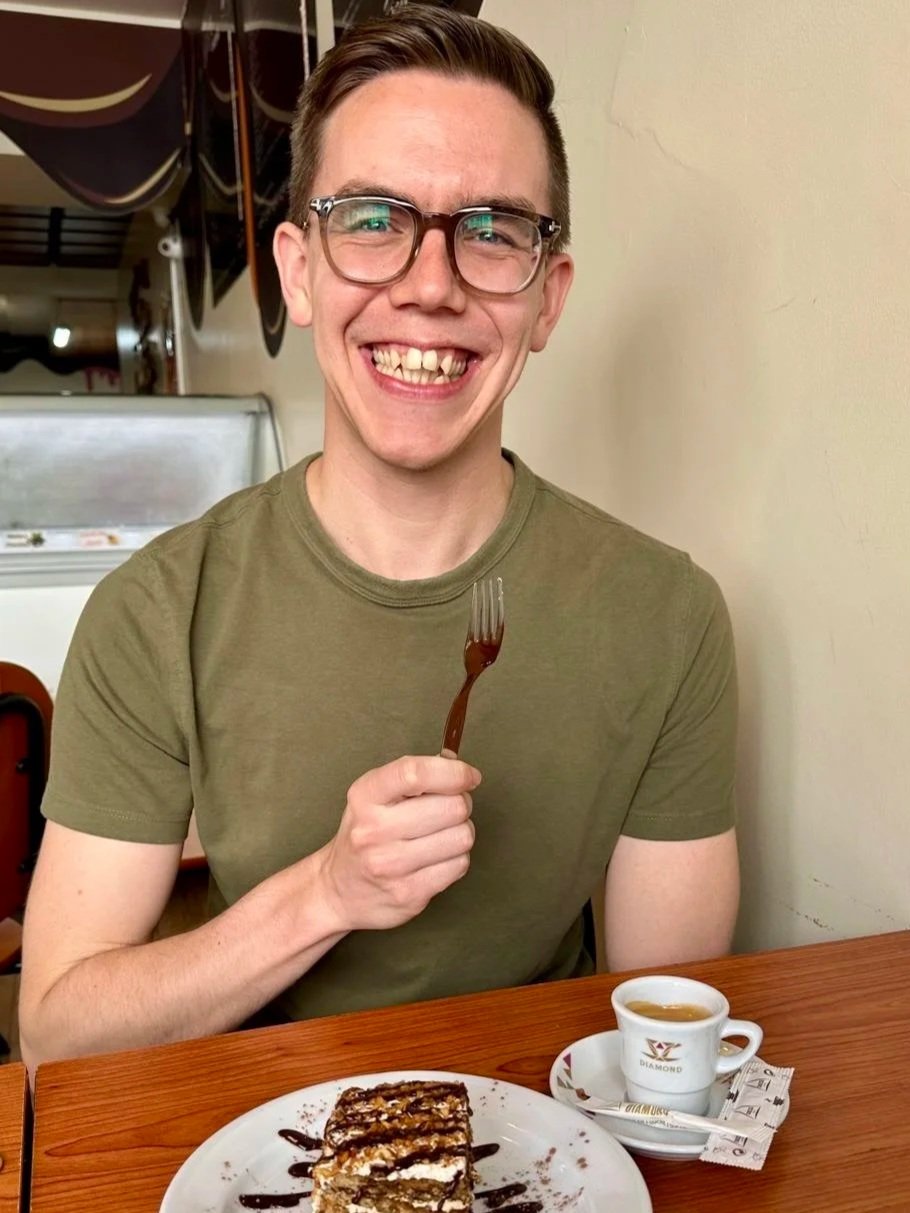 Mark Shelvock smiling over cake and an espresso