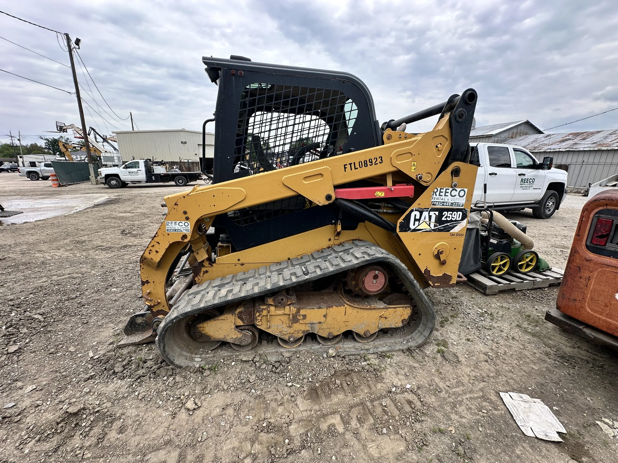 Yellow CAT 259D compact track loader parked at a construction equipment rental yard.