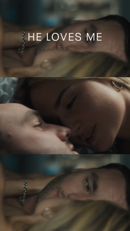 Close-up of a couple lying in bed, gazing at each other intimately, with the text 'HE LOVES ME' overlaid.