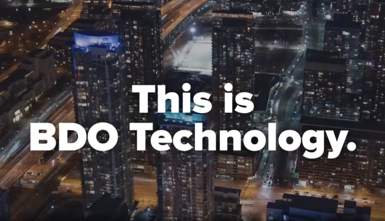 Nighttime aerial view of a city with illuminated skyscrapers, highways, and a tennis court, overlaid with the text "This is BDO Technology."