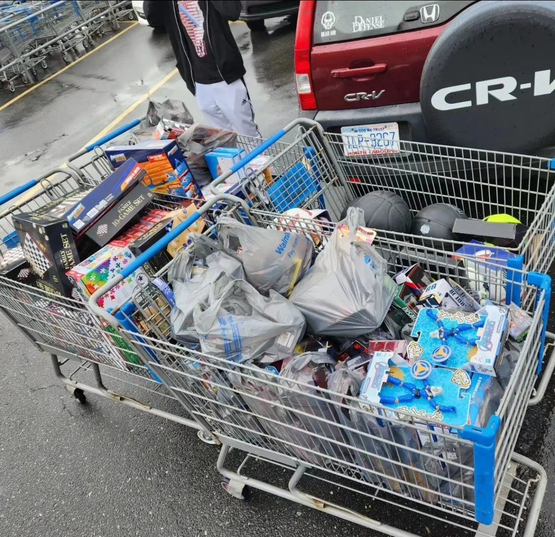 Shopping carts filled with various grocery and household items, parked in a parking lot near a red Honda CR-V.