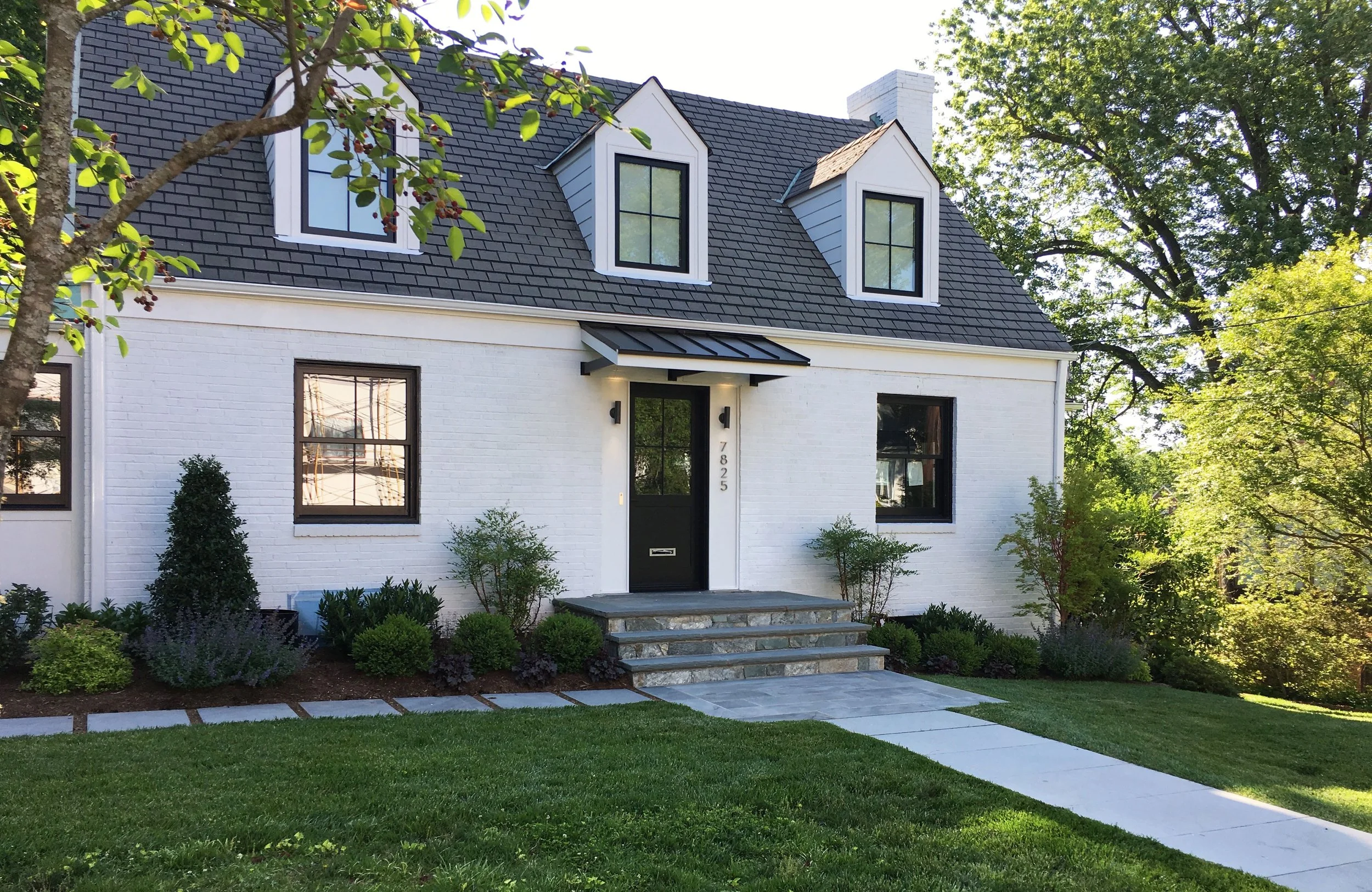 Clean lines and beautiful natural stone form a simple walkway to compliment the tasteful renovation of this traditional Cape Cod style house in Bethesda, MD
