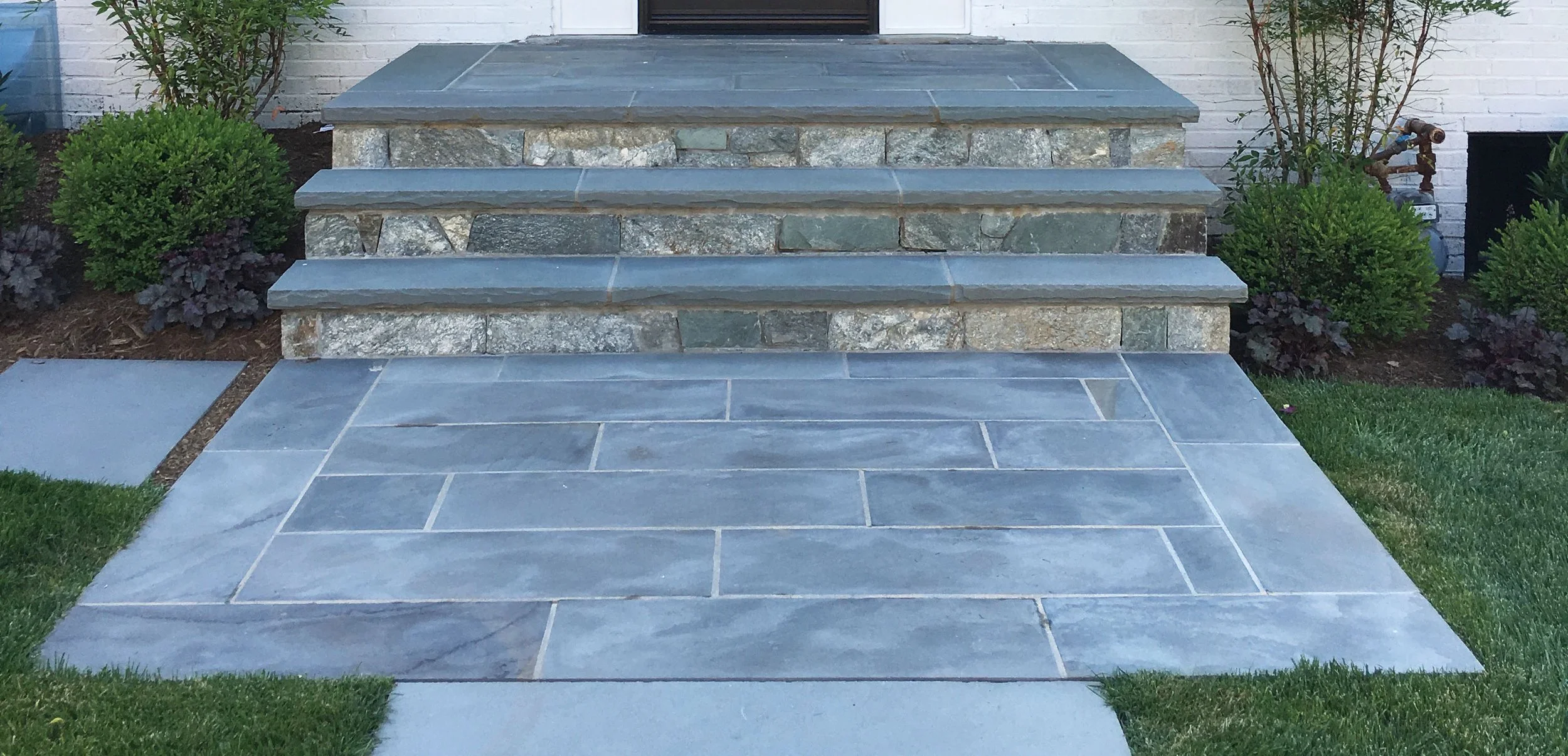 Generous natural stone entry landing. Simple landscape design in Bethesda, MD