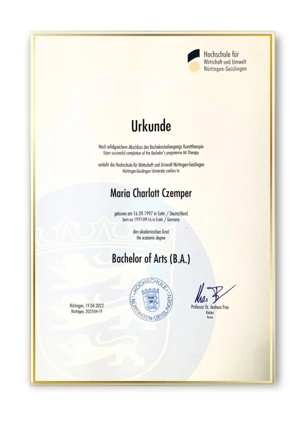 Fotografie eines Diploms der Hochschule für Wirtschaft und Umwelt Nürtingen-Geislingen, verliehen an Maria Charlott Czemper für den Abschluss eines Bachelors in Kunsttherapie. Das Diplom ist mit Stempel, Unterschrift und Datum versehen.
