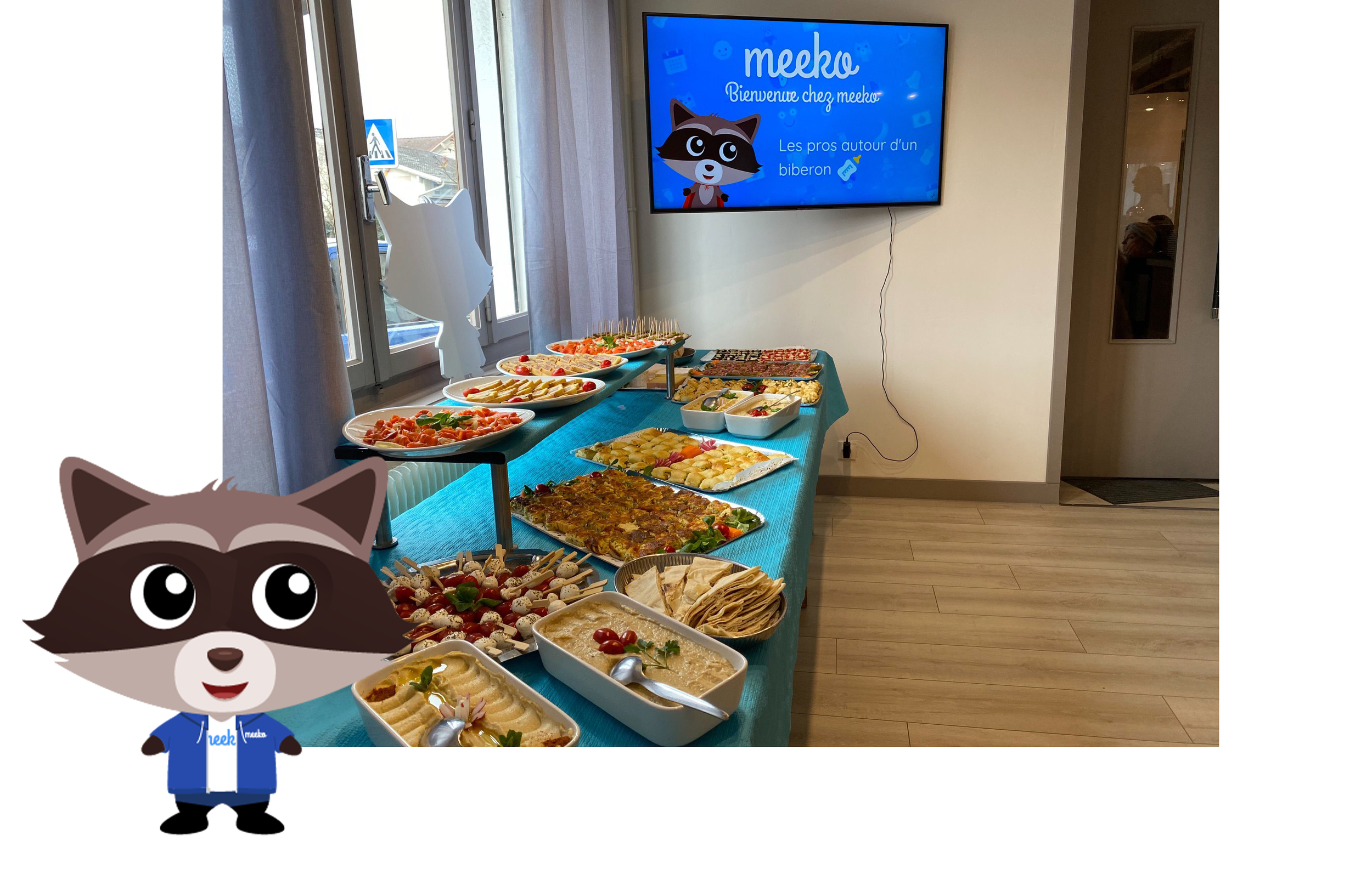 A buffet table with various appetizers and snacks, situated in a room with a large window and a wall-mounted TV displaying a cartoon raccoon character and French text, with part of a cartoon raccoon superimposed in the foreground.