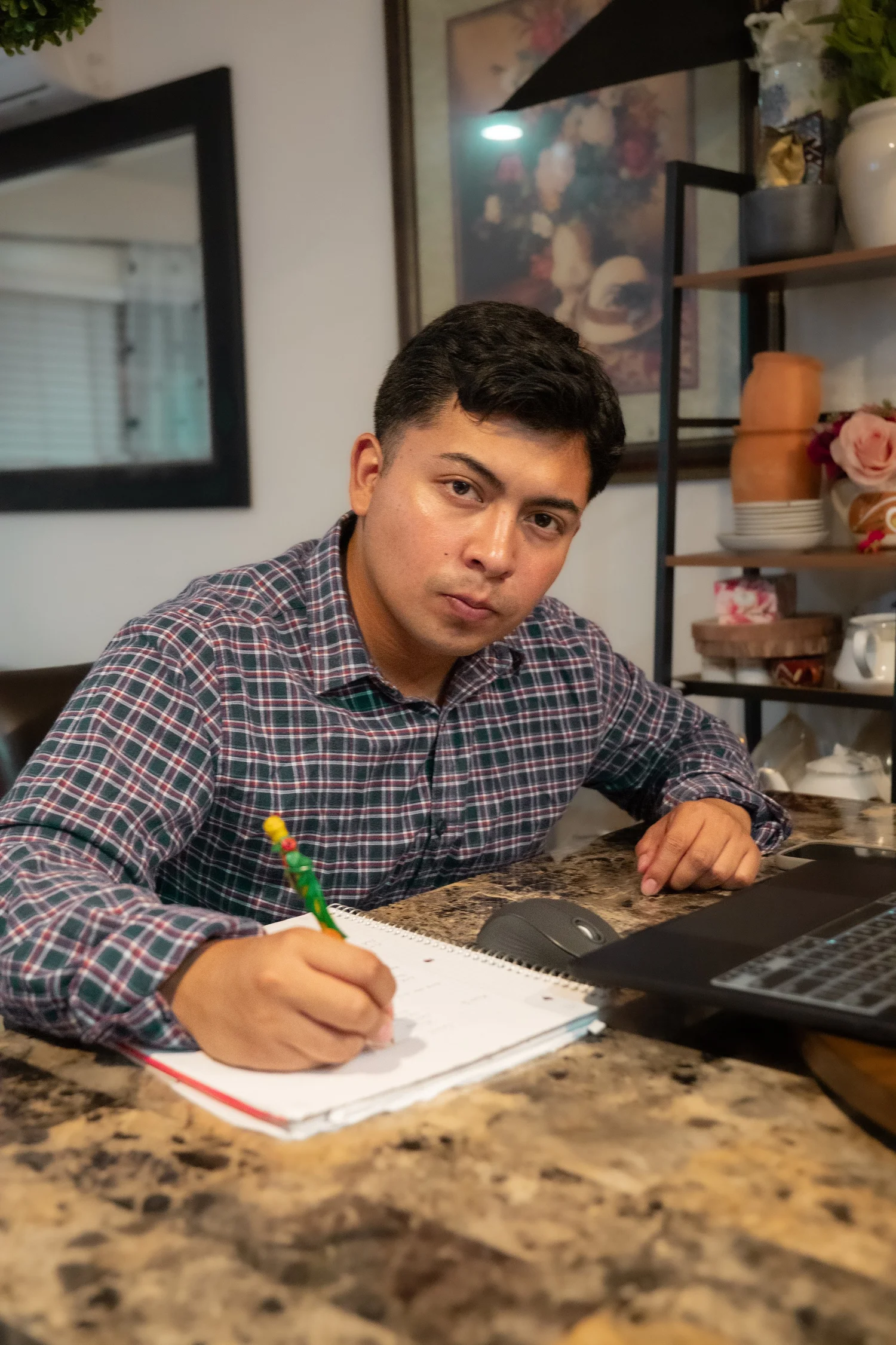 Samuel Perez working with a notebook and laptop.