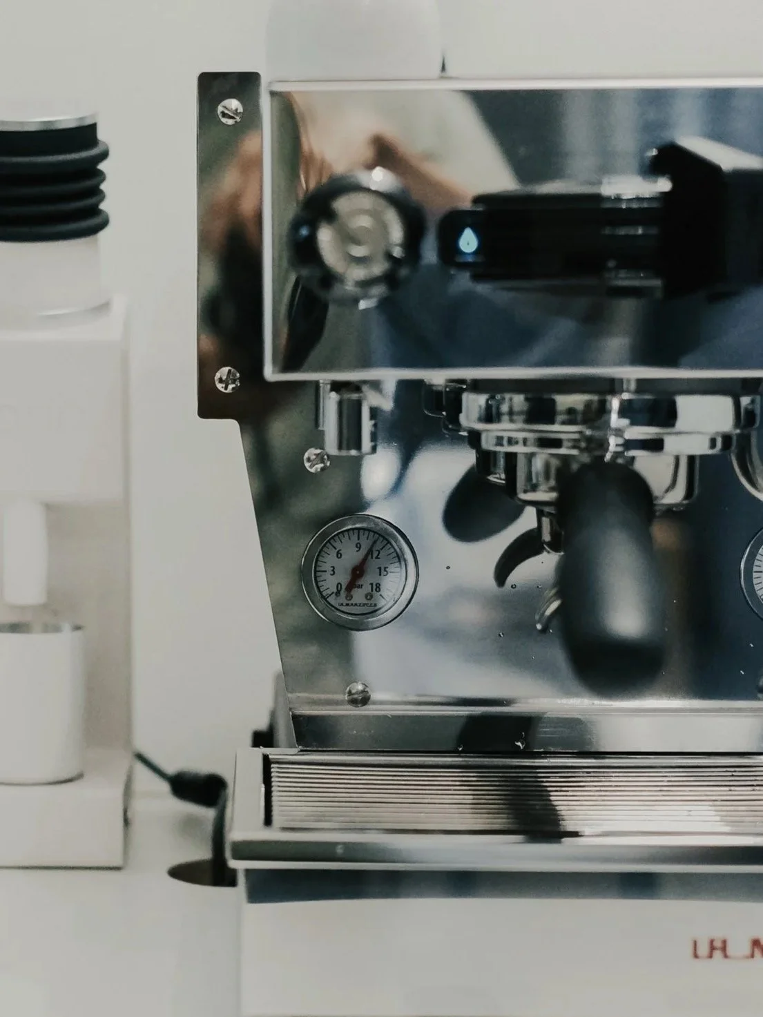 An espresso machine and grinder on a white bench