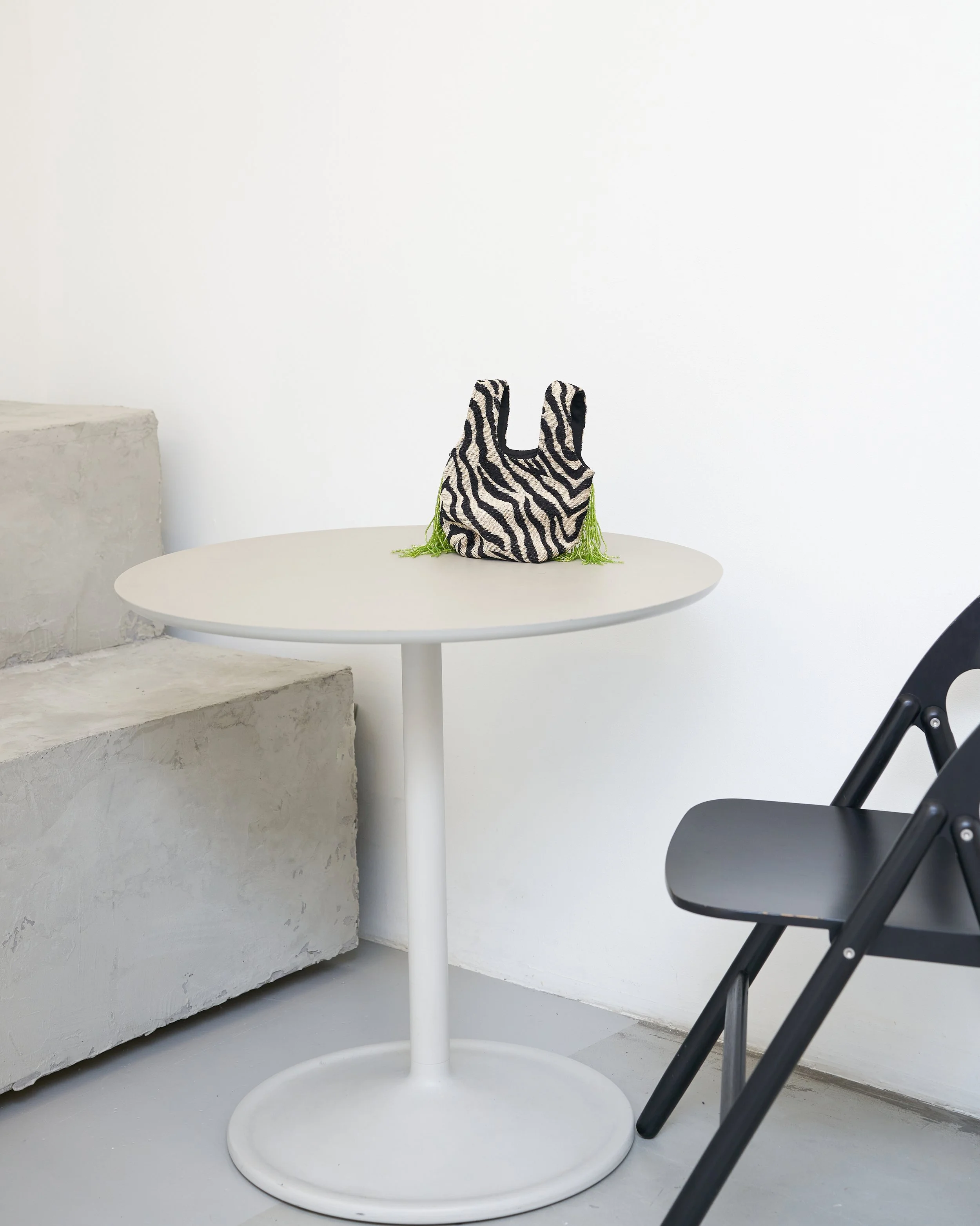 Statement handbag styled on a white table, shopping support by Styled by Meeshamore