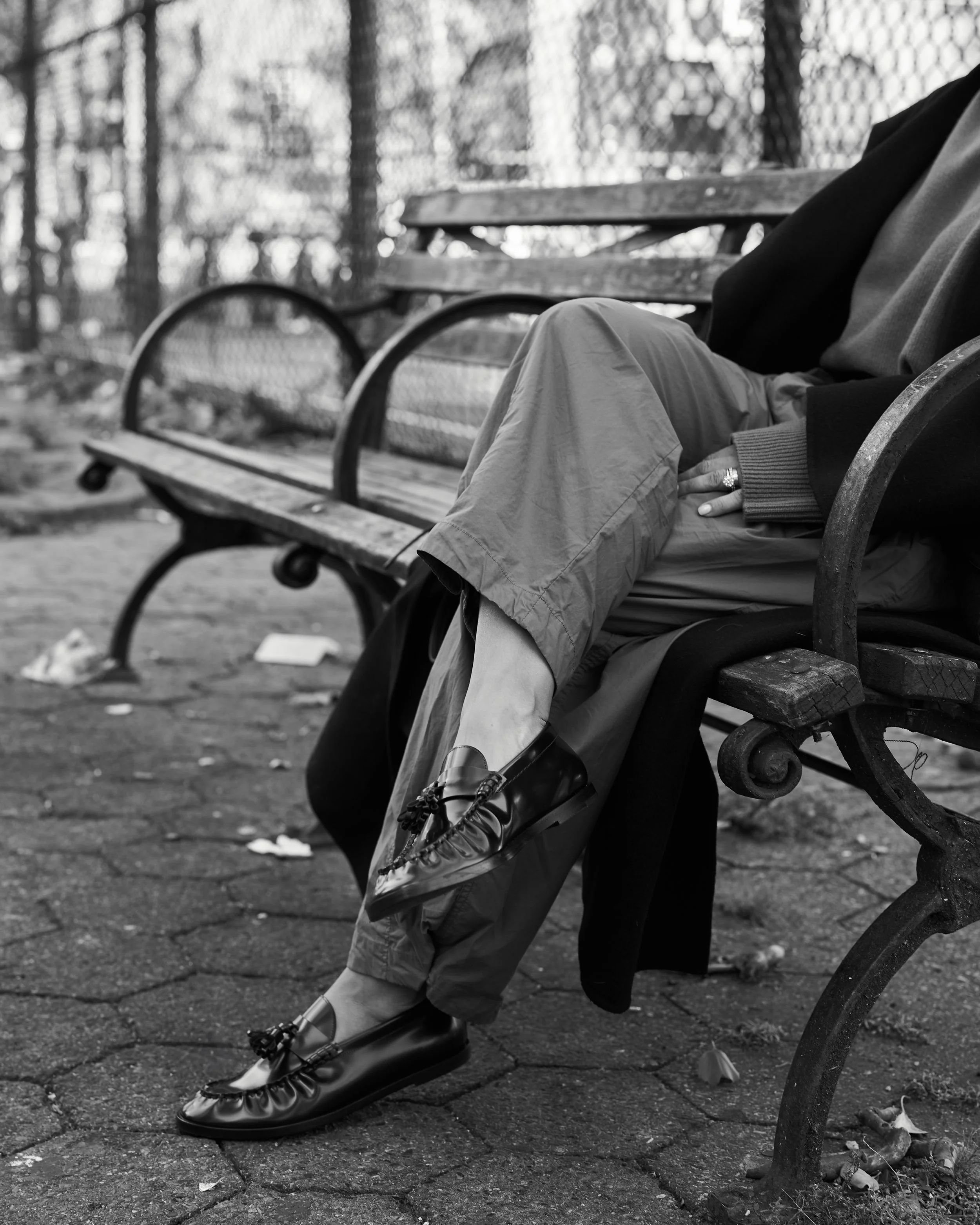 Black and white styling detail of tailored trousers and loafers on a park bench, Styled by Meeshamore