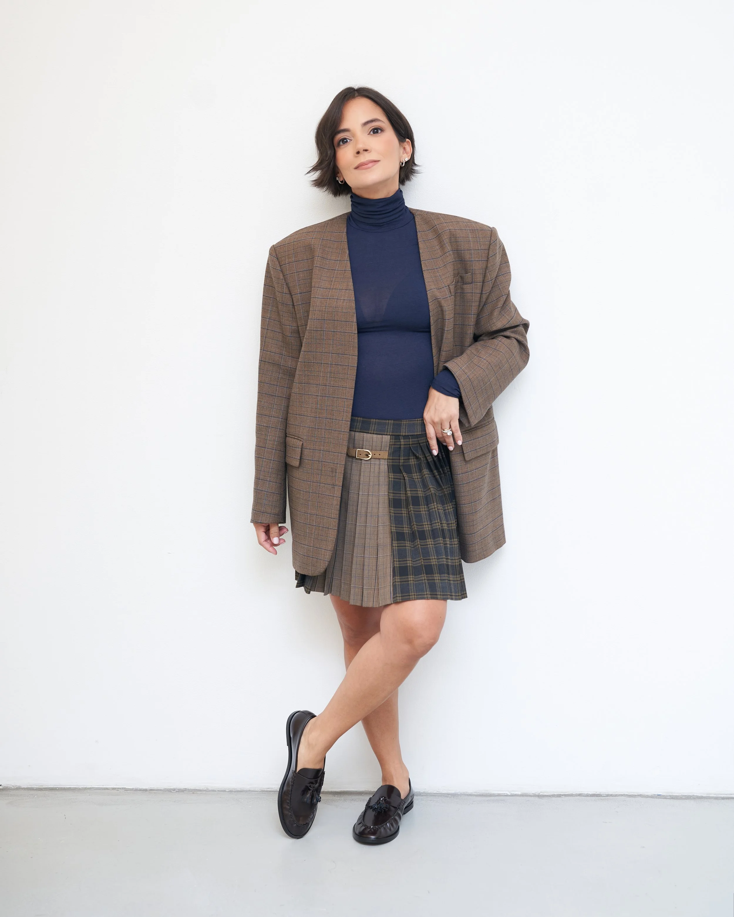 Brown oversized blazer with a navy turtleneck, plaid pleated mini skirt and loafers