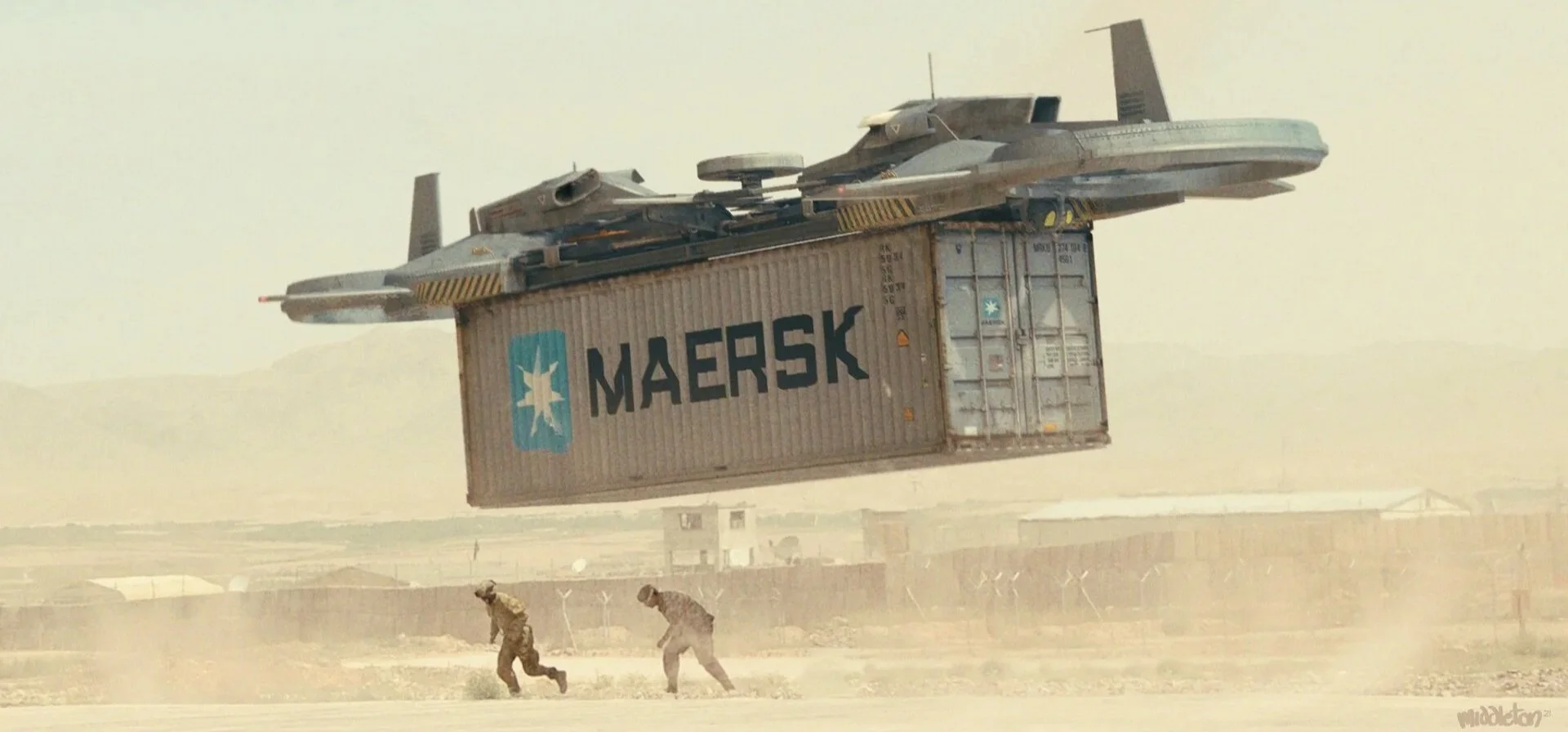 A military aircraft is flying just above a large shipping container with the MAERSK logo in a desert landscape. Two soldiers are running below, kicking up dust.