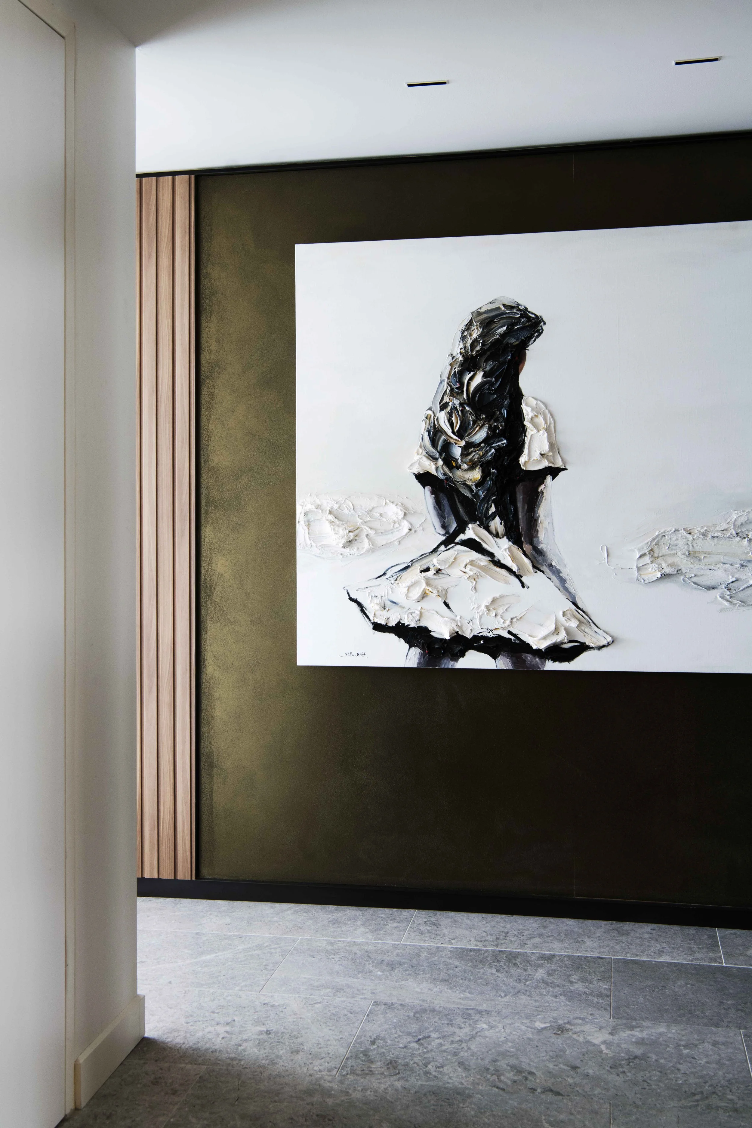 Interior of an art gallery featuring a painting of a woman in a white dress with long dark hair, sitting on a snowy landscape.
