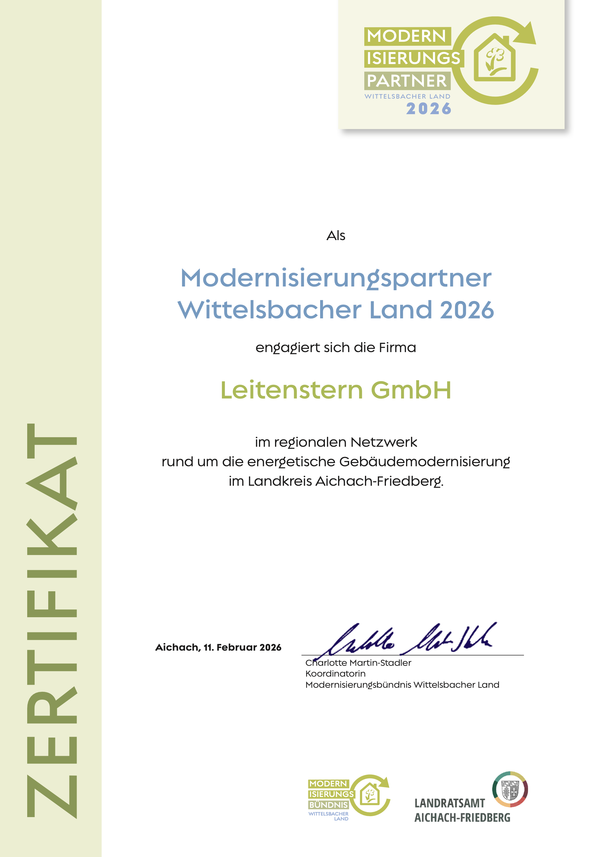 Das Dokument ist eine Urkunde vom Landratsamt Aichach-Friedberg vom 11. Februar 2026, unterschrieben von Charlotte Martin-Stadler, Koordinatorin des Modernisierungsbündnis Wittelsbacher Land. Es betont die Zusammenarbeit mit der Firma Leitenstern GmbH im Rahmen der energetischen Gebäudemodernisierung im Landkreis Aichach-Friedberg.