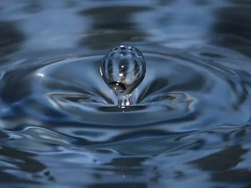 Goutte d'eau tombant dans l'eau, créant des ondulations