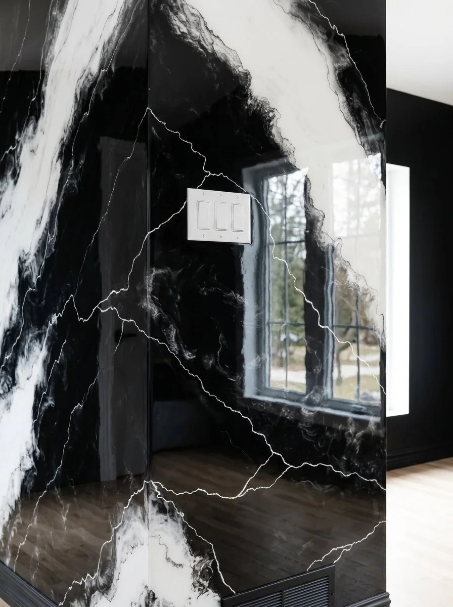 Mur en marbre noir et blanc avec des veines blanches, reflet d'une fenêtre à l'extérieur.