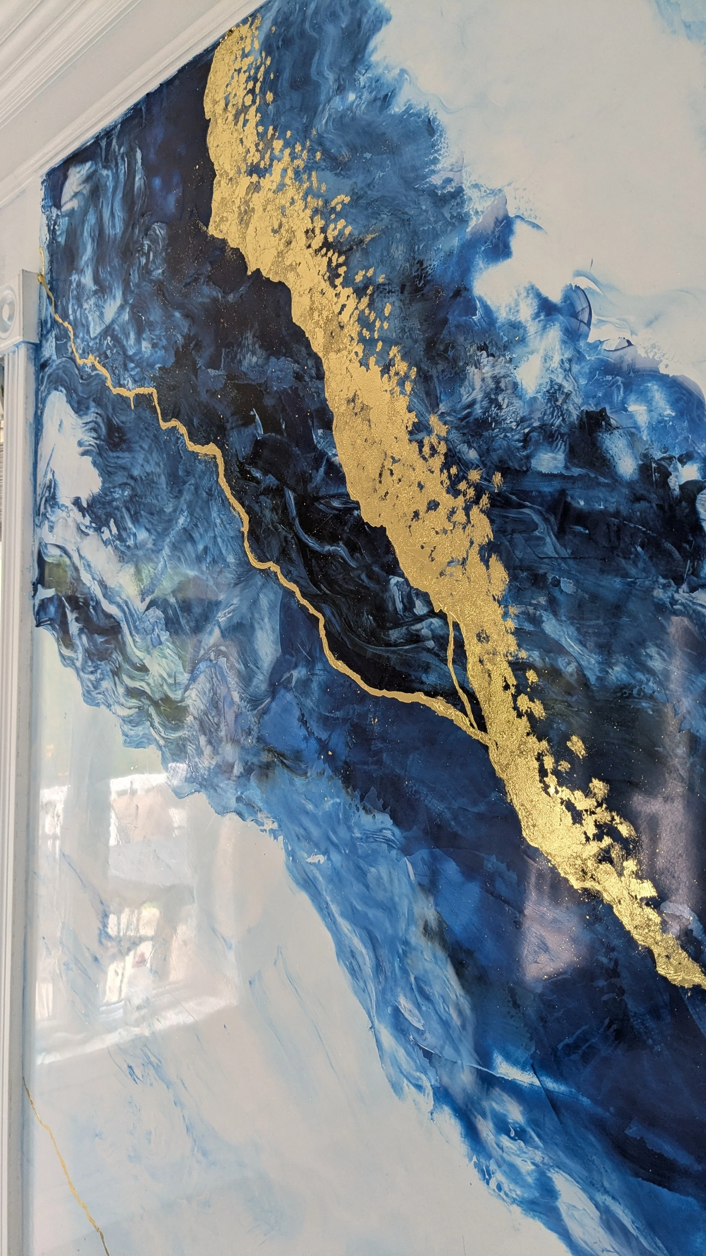 Peinture abstraite avec des touches de bleu, noir, blanc et or.