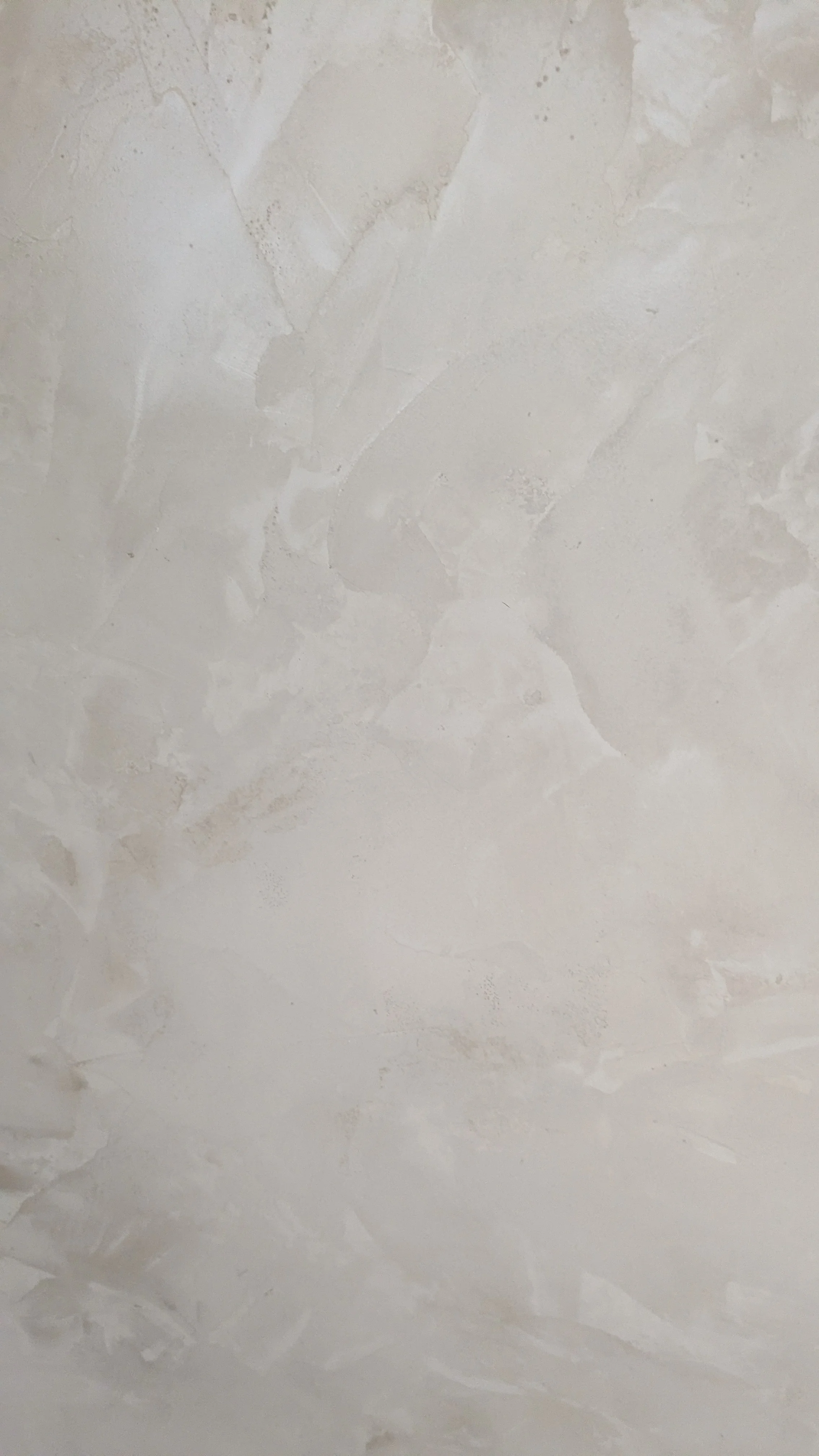 Surface murale en plâtre ou en enduit avec des imperfections et des textures irrégulières.