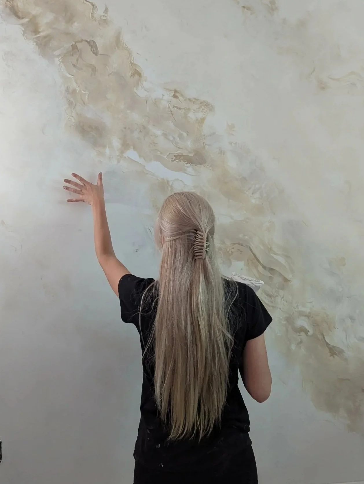 un mur avec des motifs de marbre ou de peinture abstraite dans des tons beige, blanc et marron. imitation marbre, faux marbre, plâtre venitien , venetian plaster, marble, murale