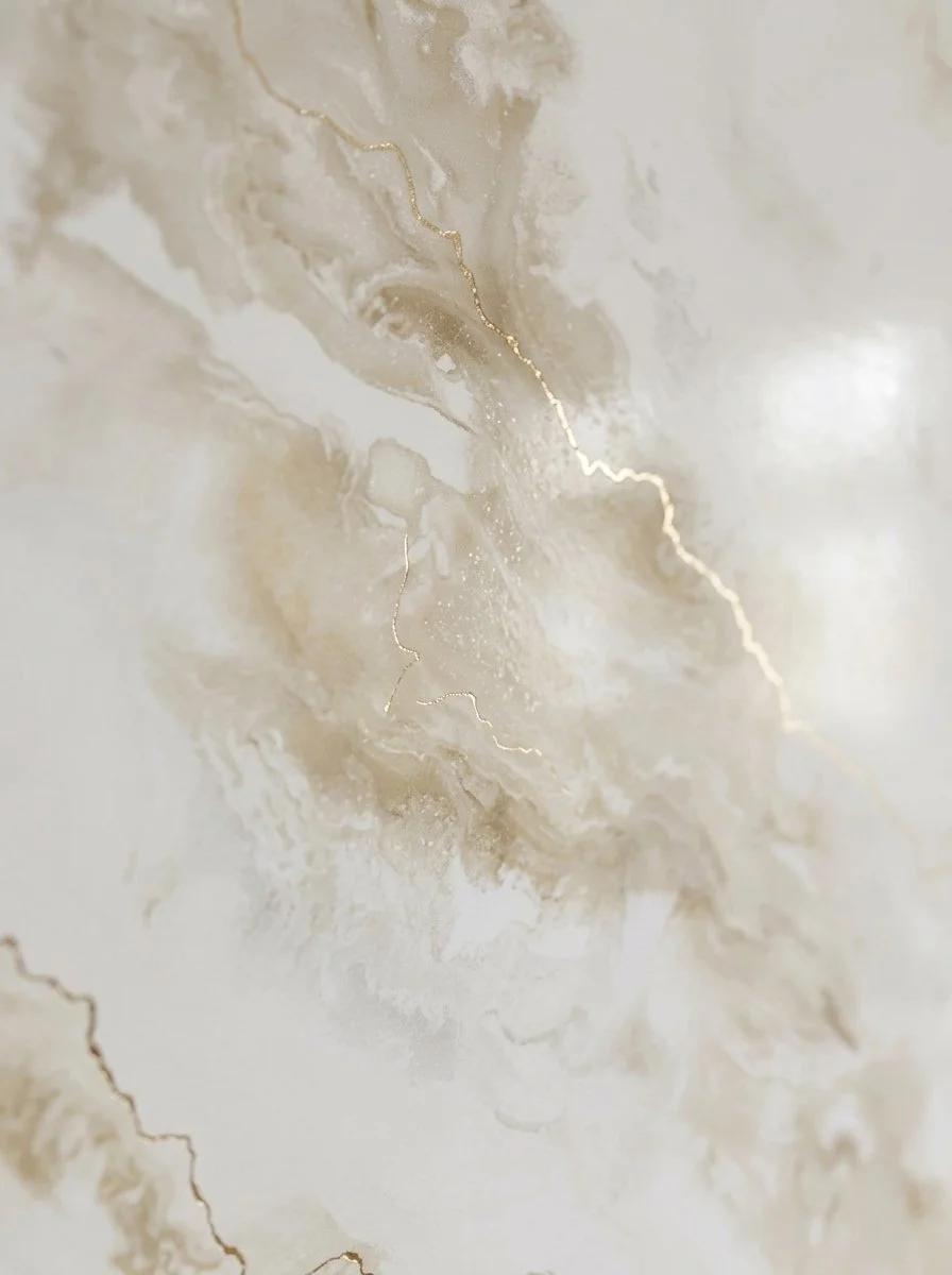 Une surface de marbre ou d'albâtre crème avec des veines dorées fluctuant à travers.