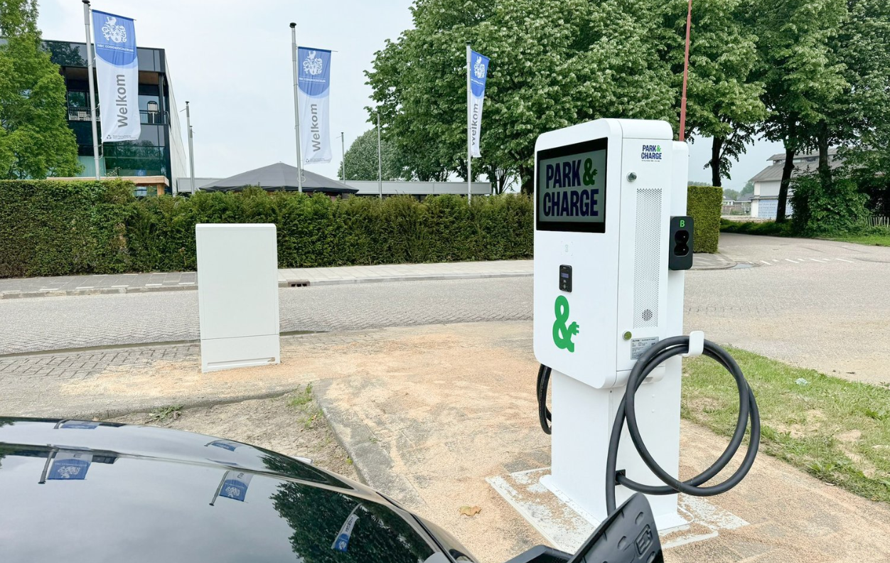 Snellader op publieke parkeerplaats met zichtbare branding