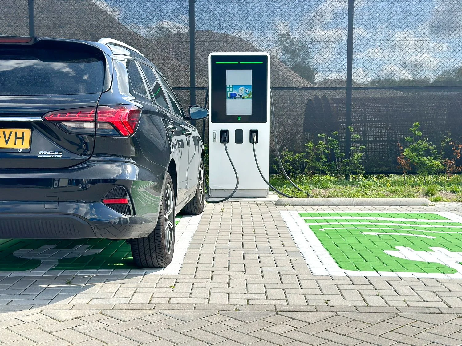 Elektrische auto wordt opgeladen bij een laadpaal van Floading op een parkeerplaats.