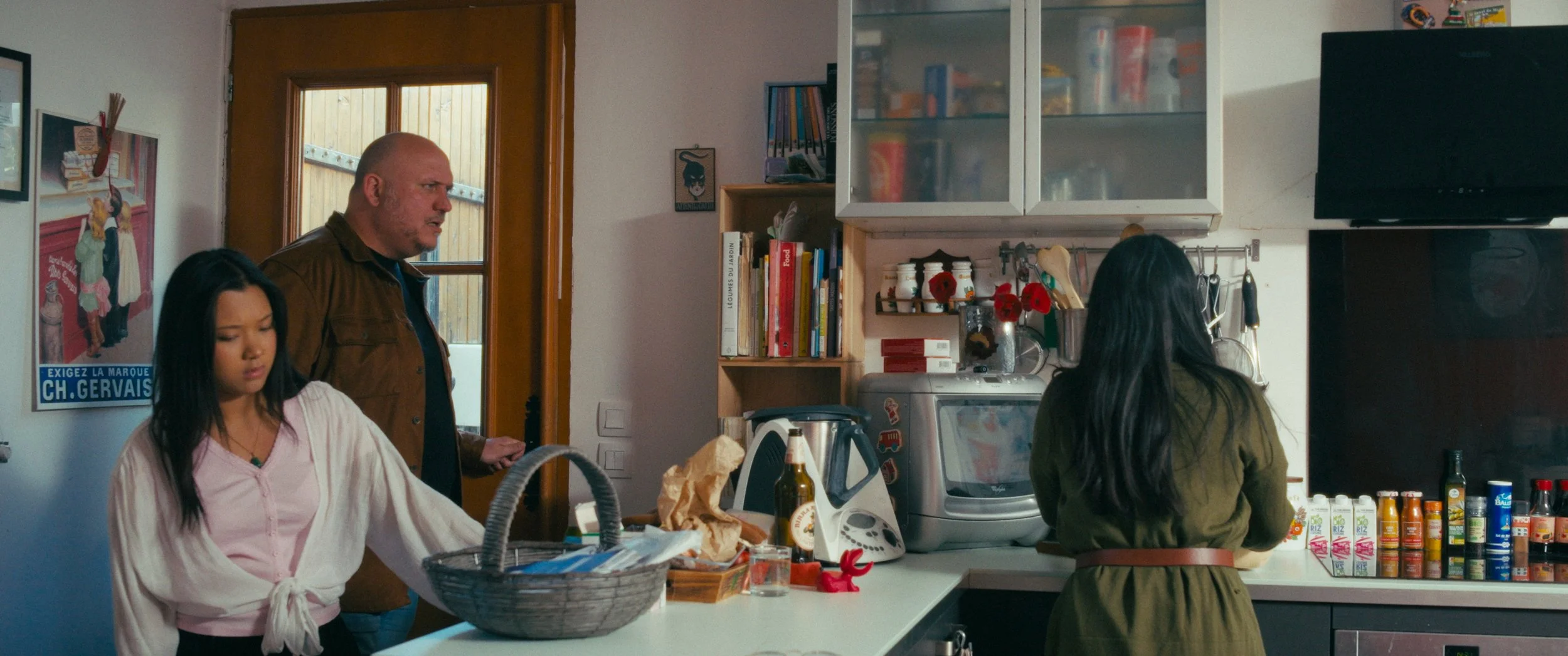 Multiple people in a kitchen entering. 