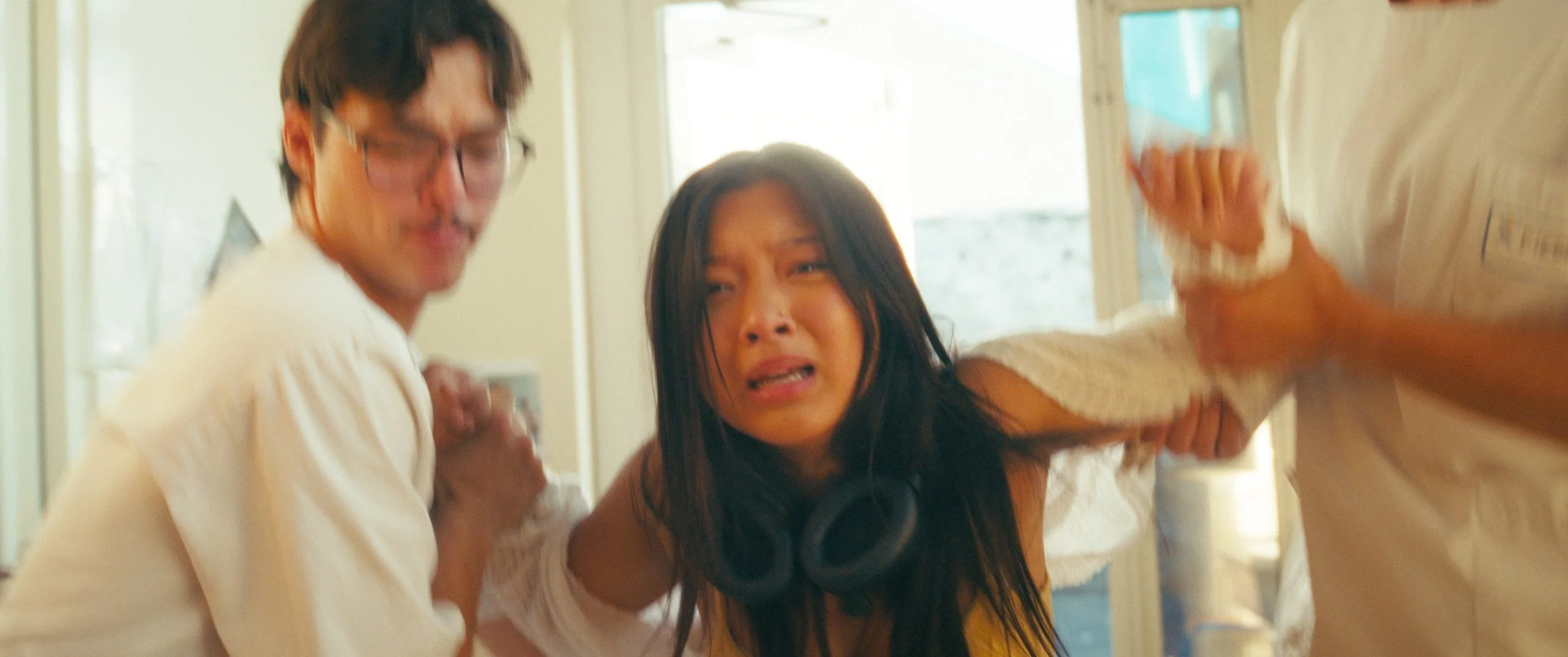 A woman is being assaulted by two men in a room, with the woman showing distress and fear.