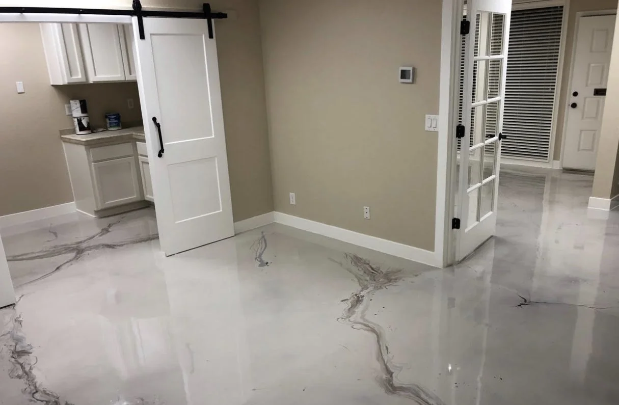 Interior room with shiny white marble flooring with darker veining, beige walls, white trim, a sliding barn door, and a set of French doors.