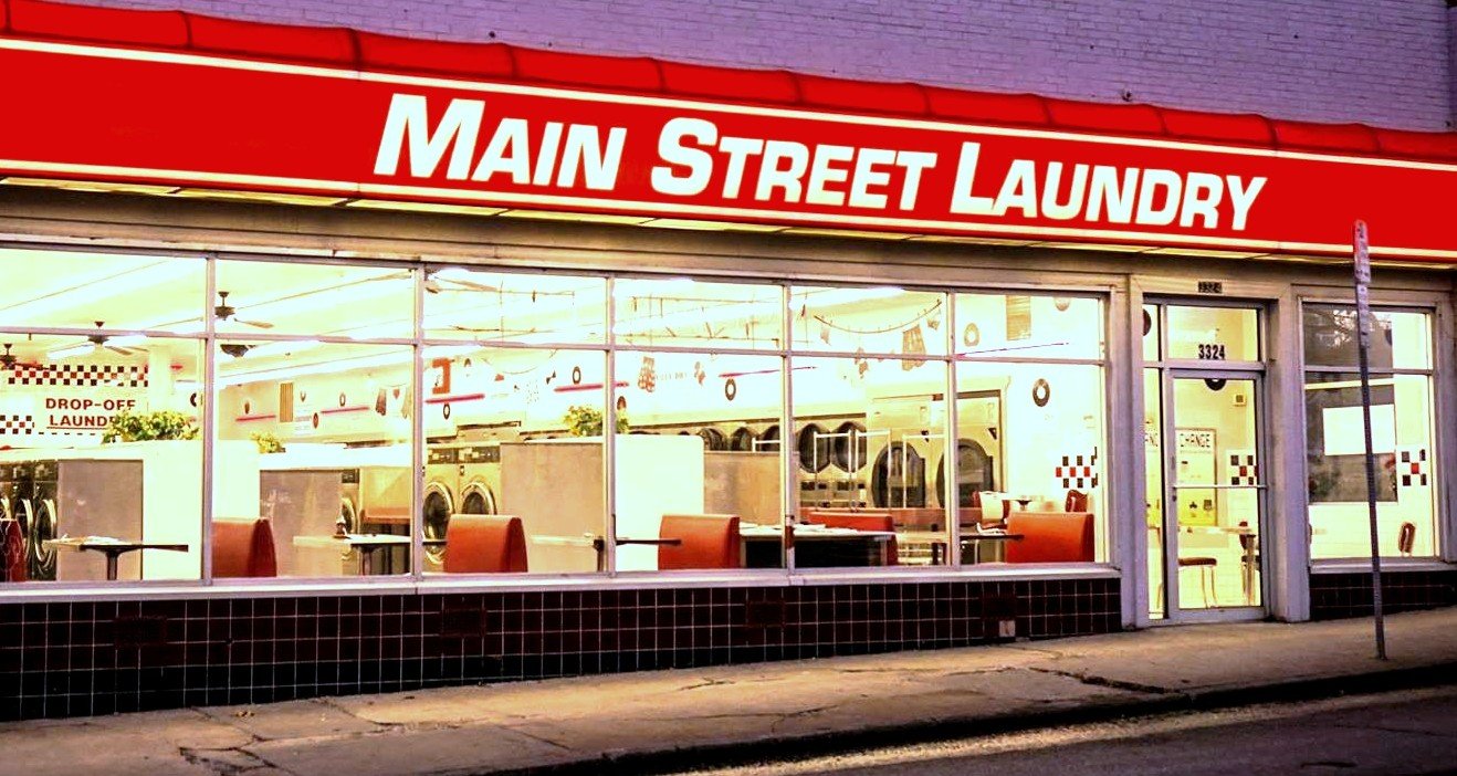 Exterior view of Main Street Laundry in Kansas City, Missouri, with bright, clean laundry facilities visible through large front windows.