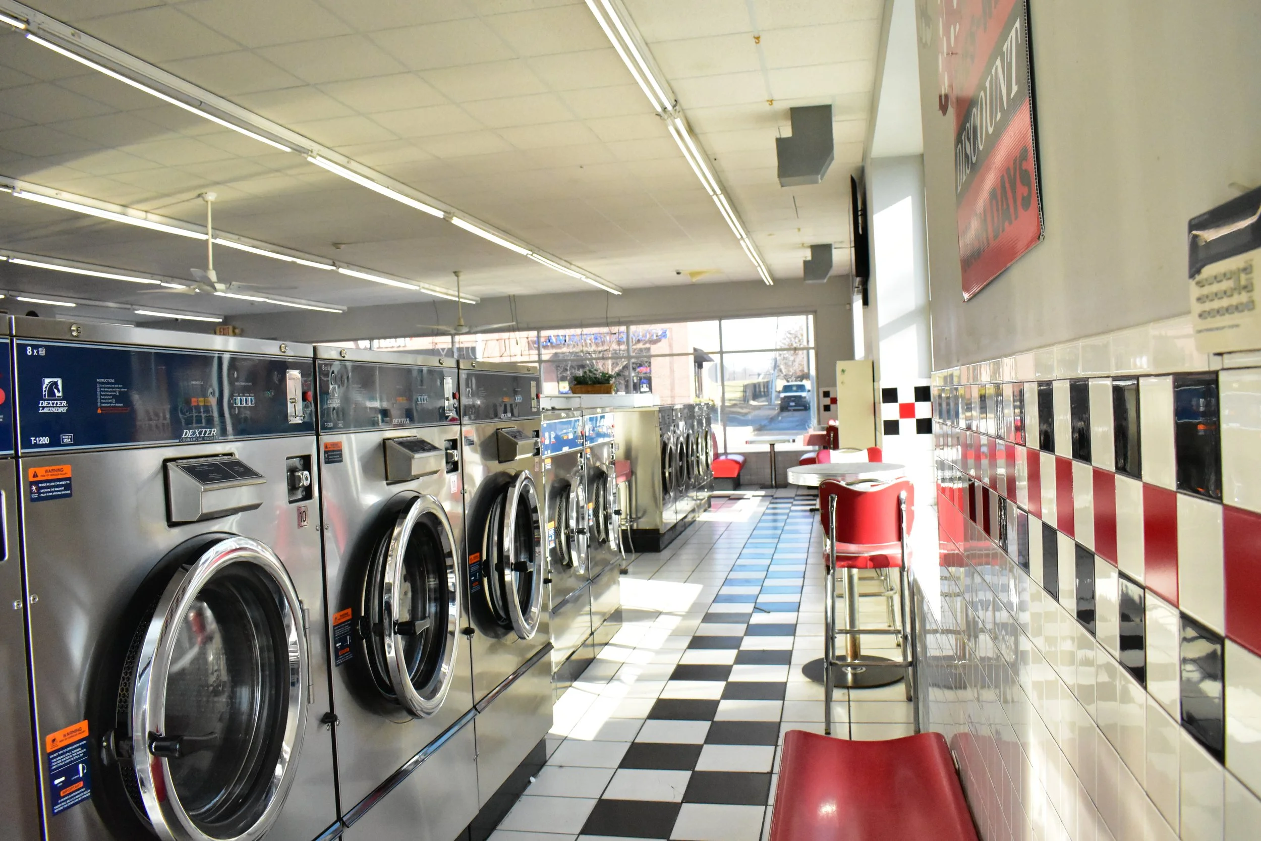 Self-service washers and dryers inside Main Street Laundry in Midtown Kansas City.