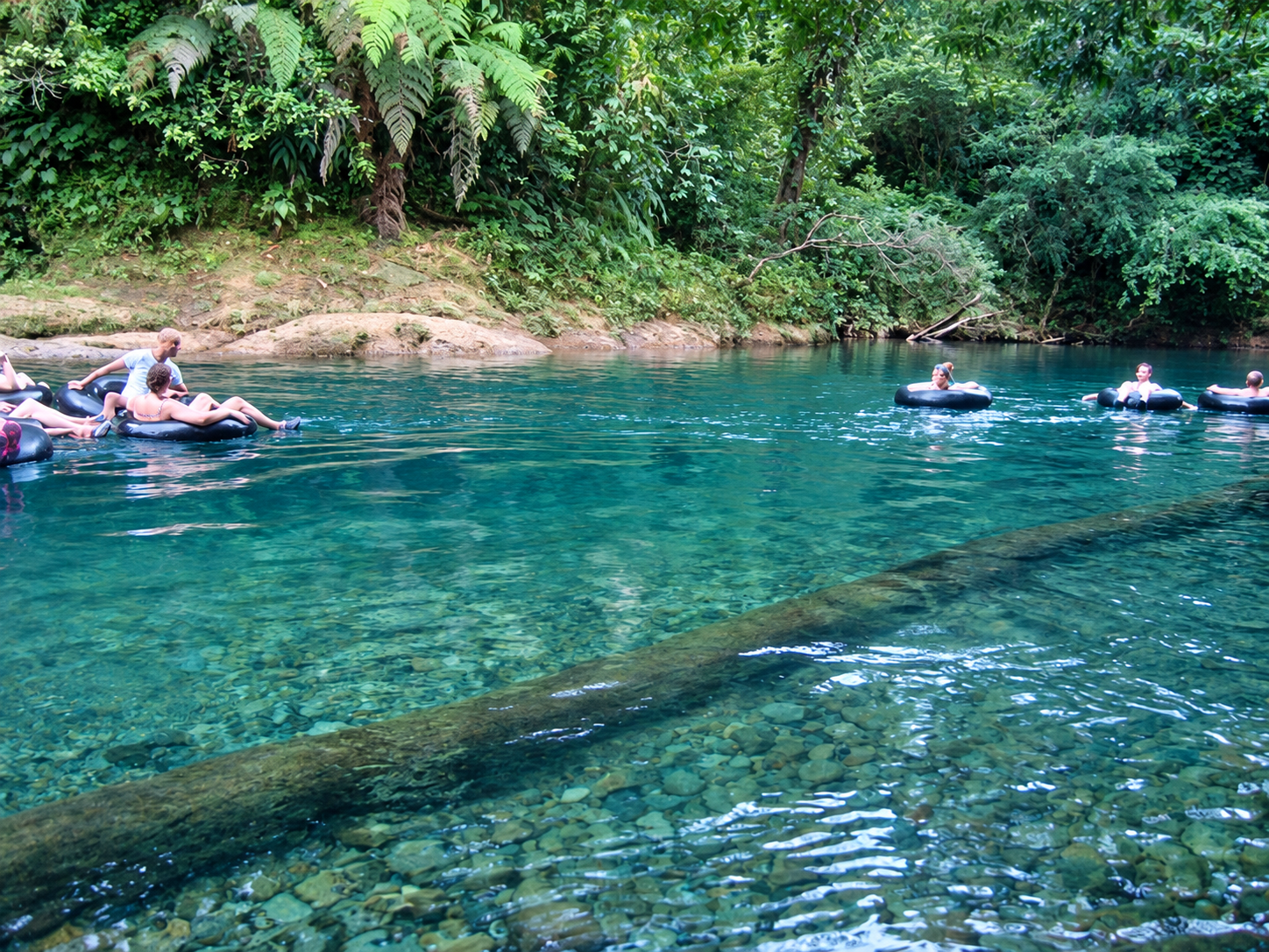 Clear river water and visitors tubing in San Cipriano Nature Reserve, Colombia.